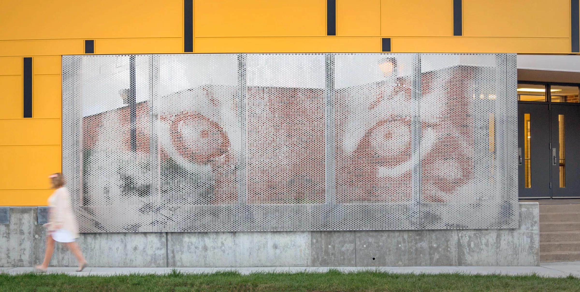 A perforated metal mural of a tiger’s eyes on a school