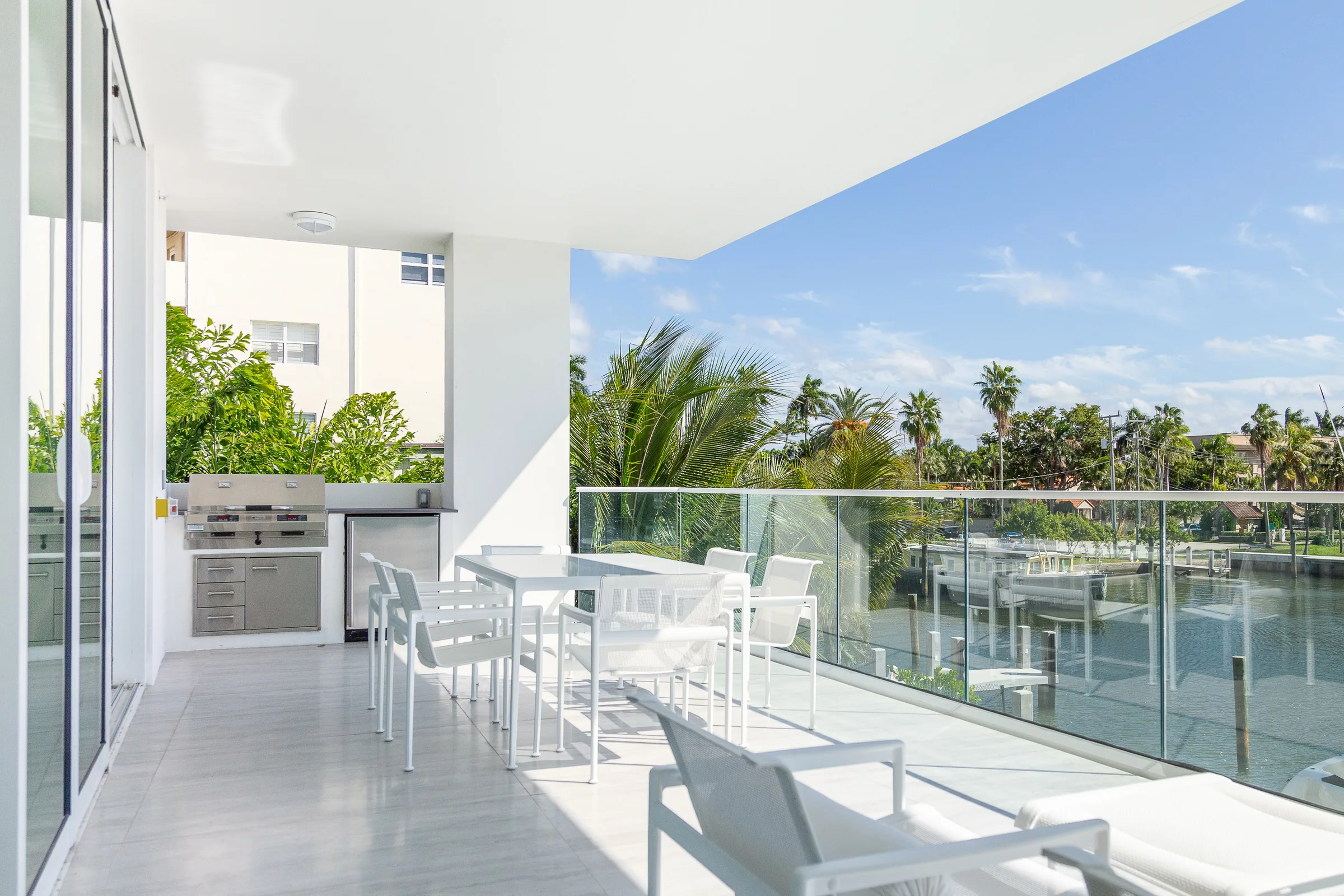 A terrace with glass railings above palm trees