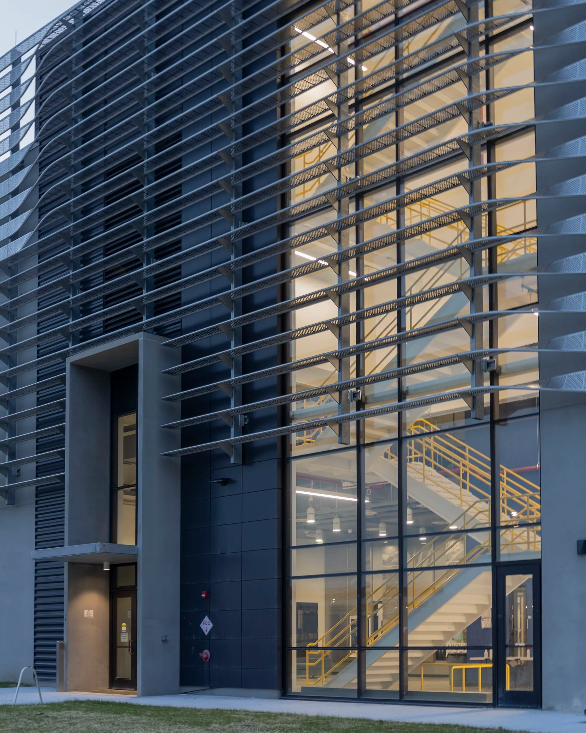 The lit glass entrance and stair behind the fins