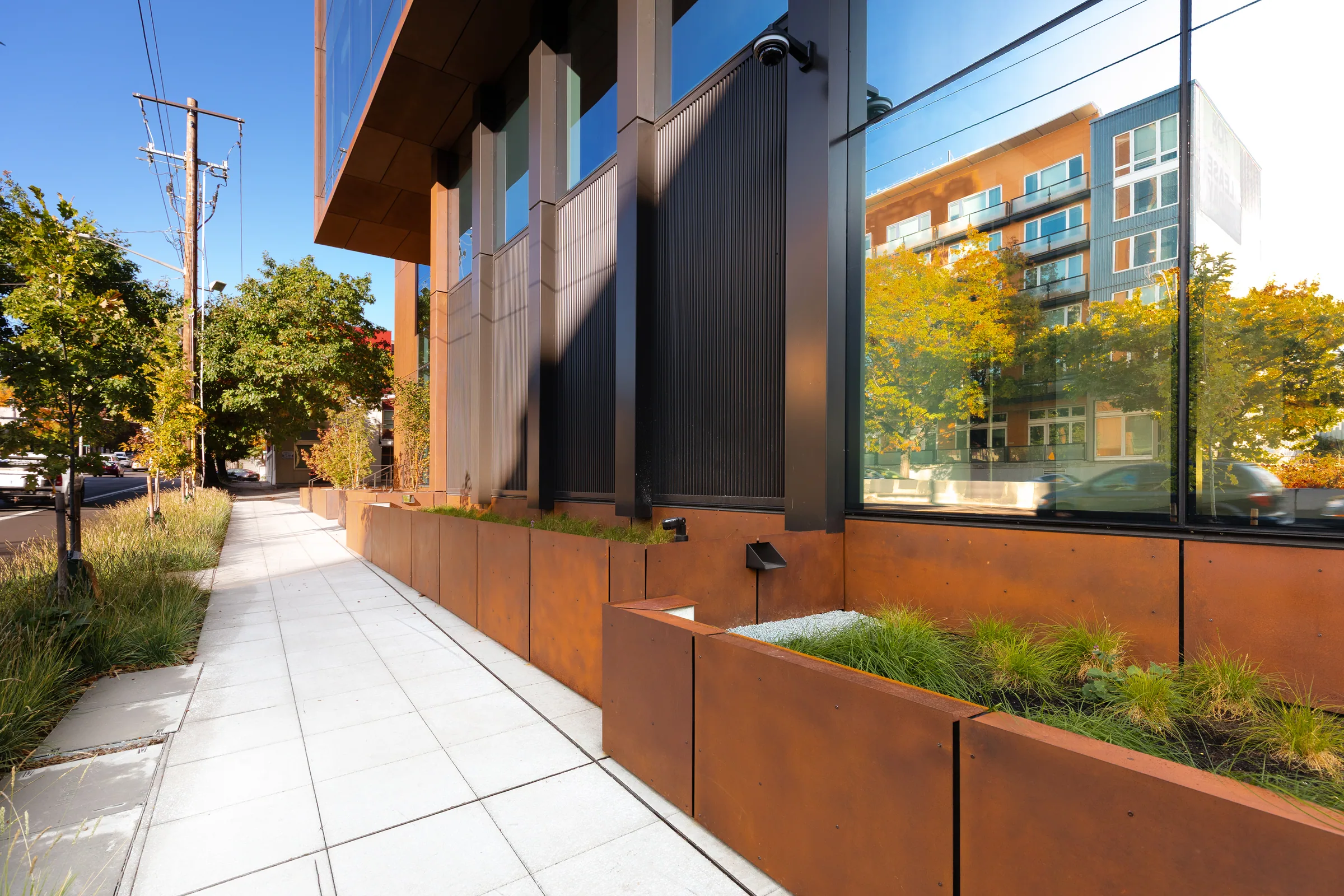 A sidewalk lined with steel planters