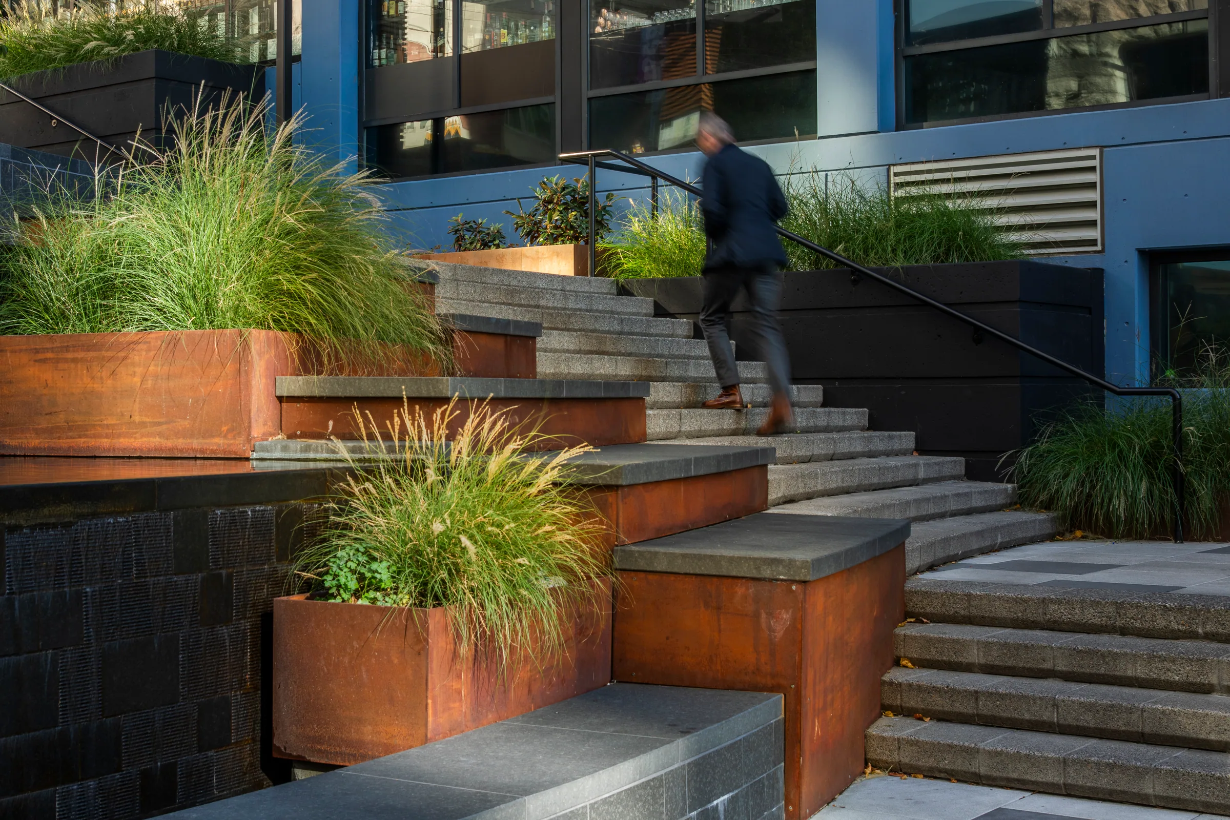 Steel planters and granite steps in late light