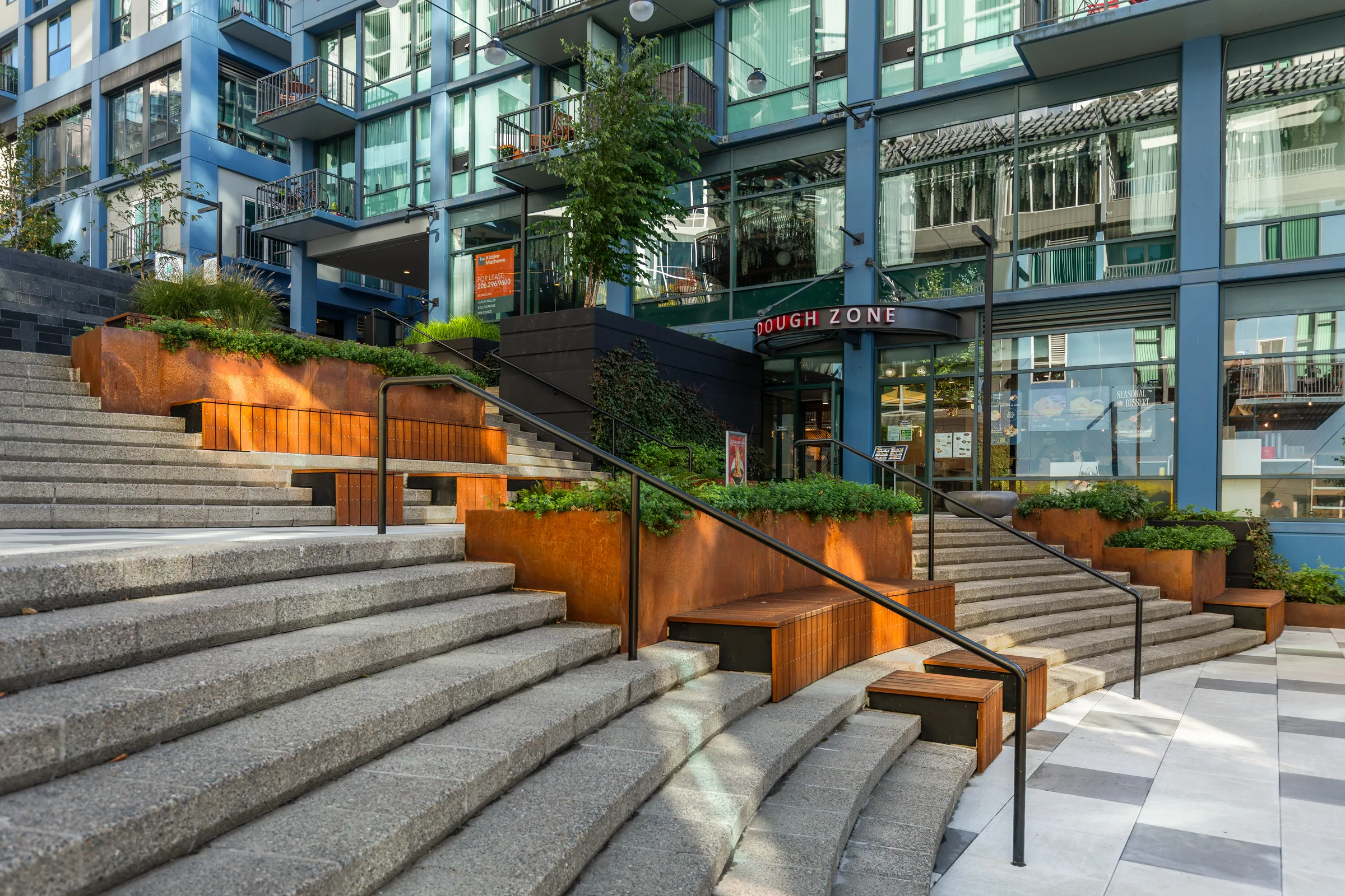The steps climbing between steel planters toward the street