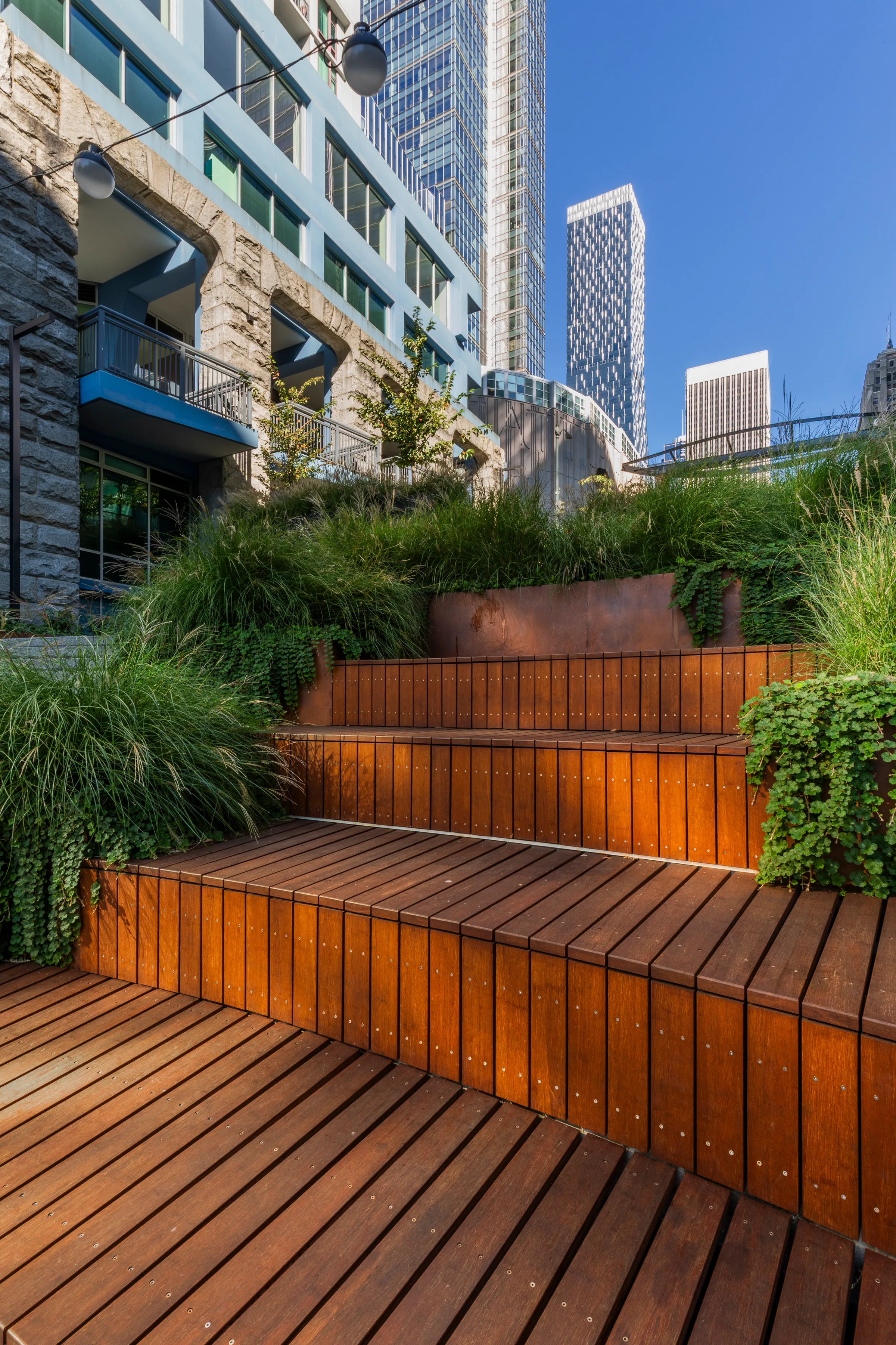 Terraced wood benches stepping up between steel planters
