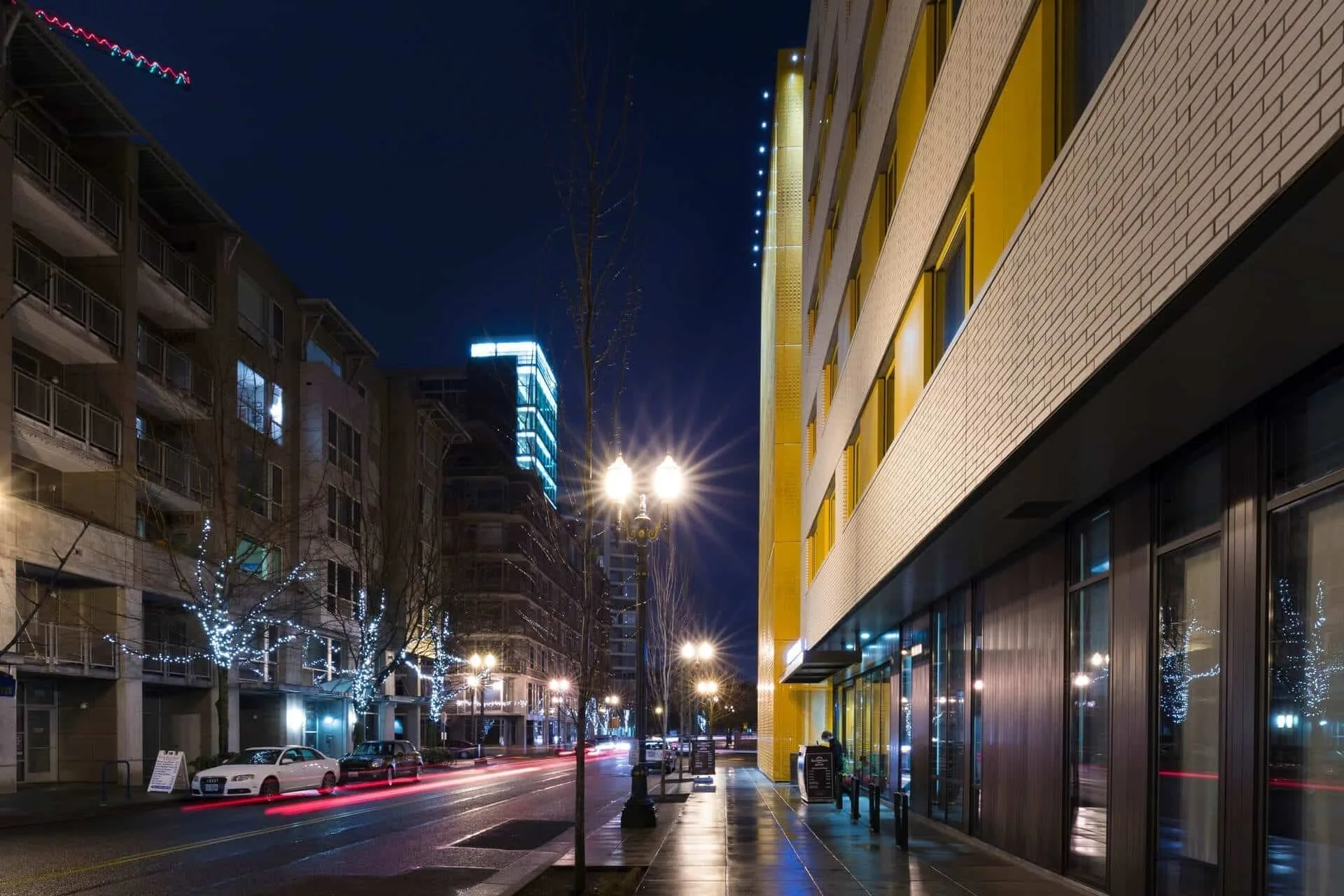 The street at night, the hotel’s brick and yellow screen running along the right