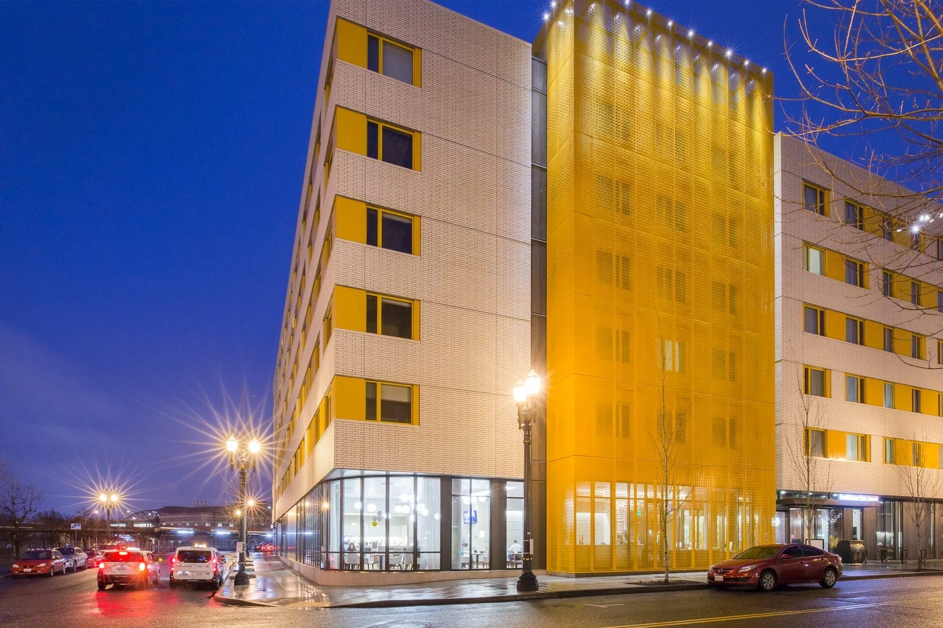 The white brick façade and glowing yellow screen against a deep blue night sky