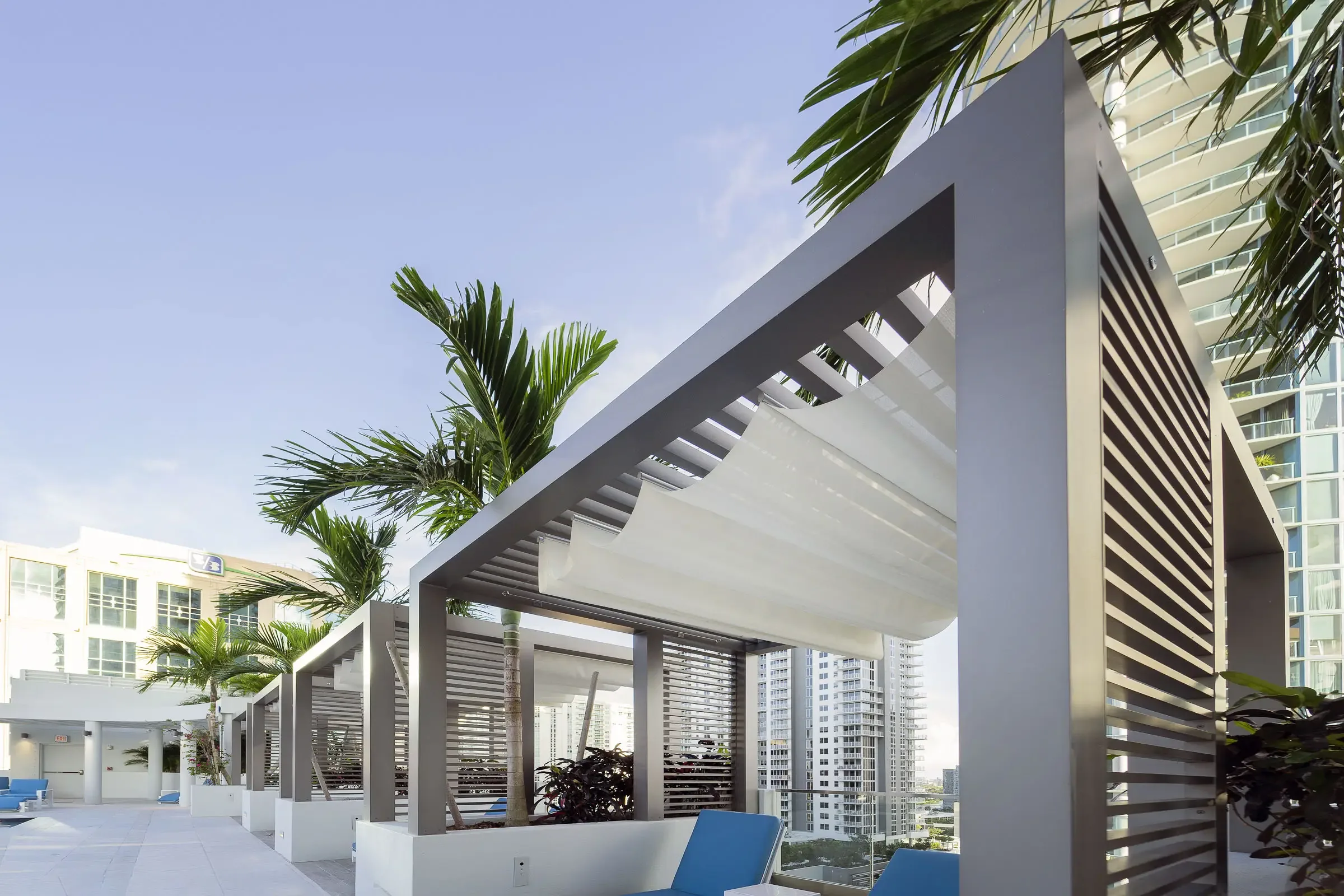 A slatted trellis framing a pool deck under palms
