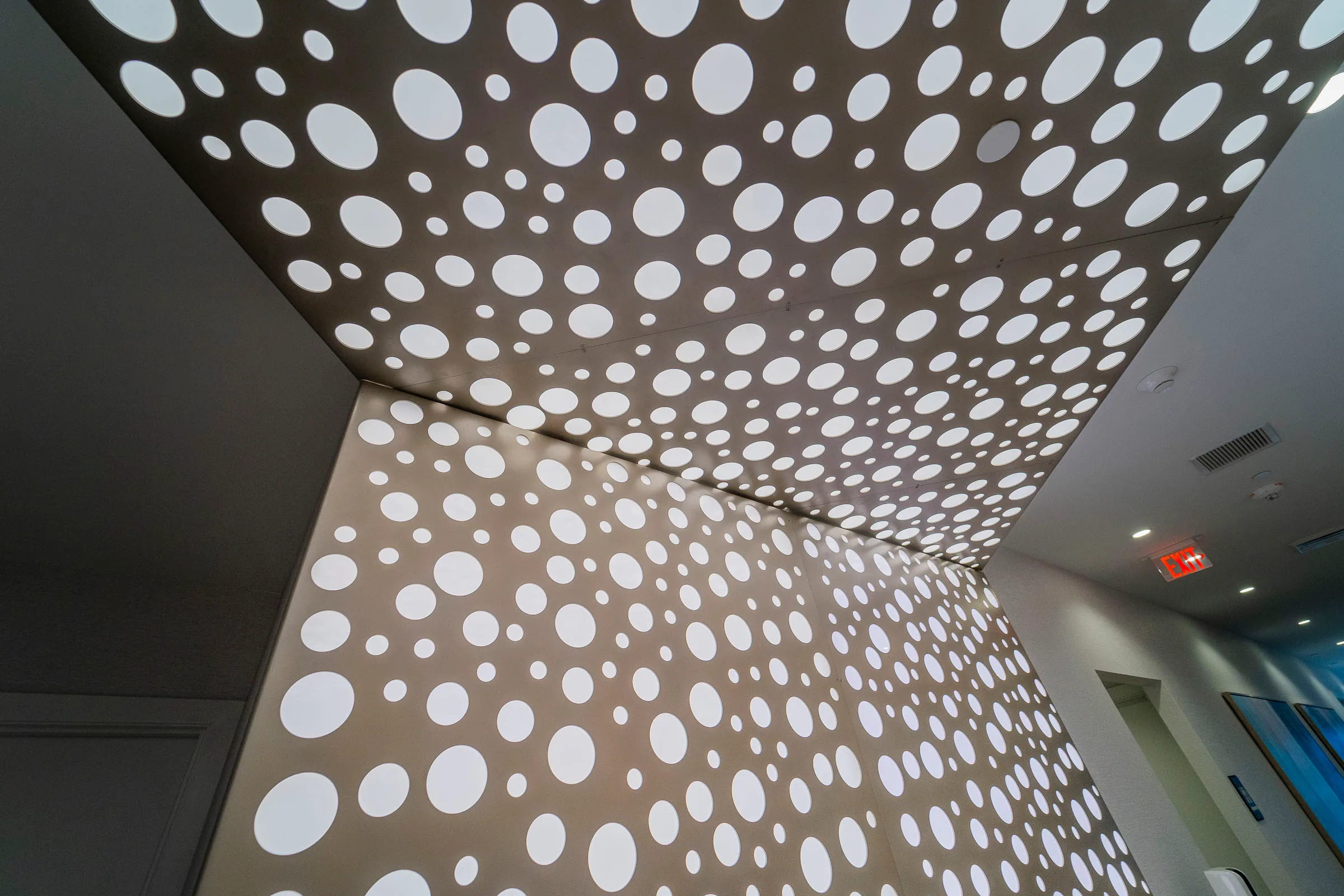 Looking up at the perforated ceiling where it folds into the wall