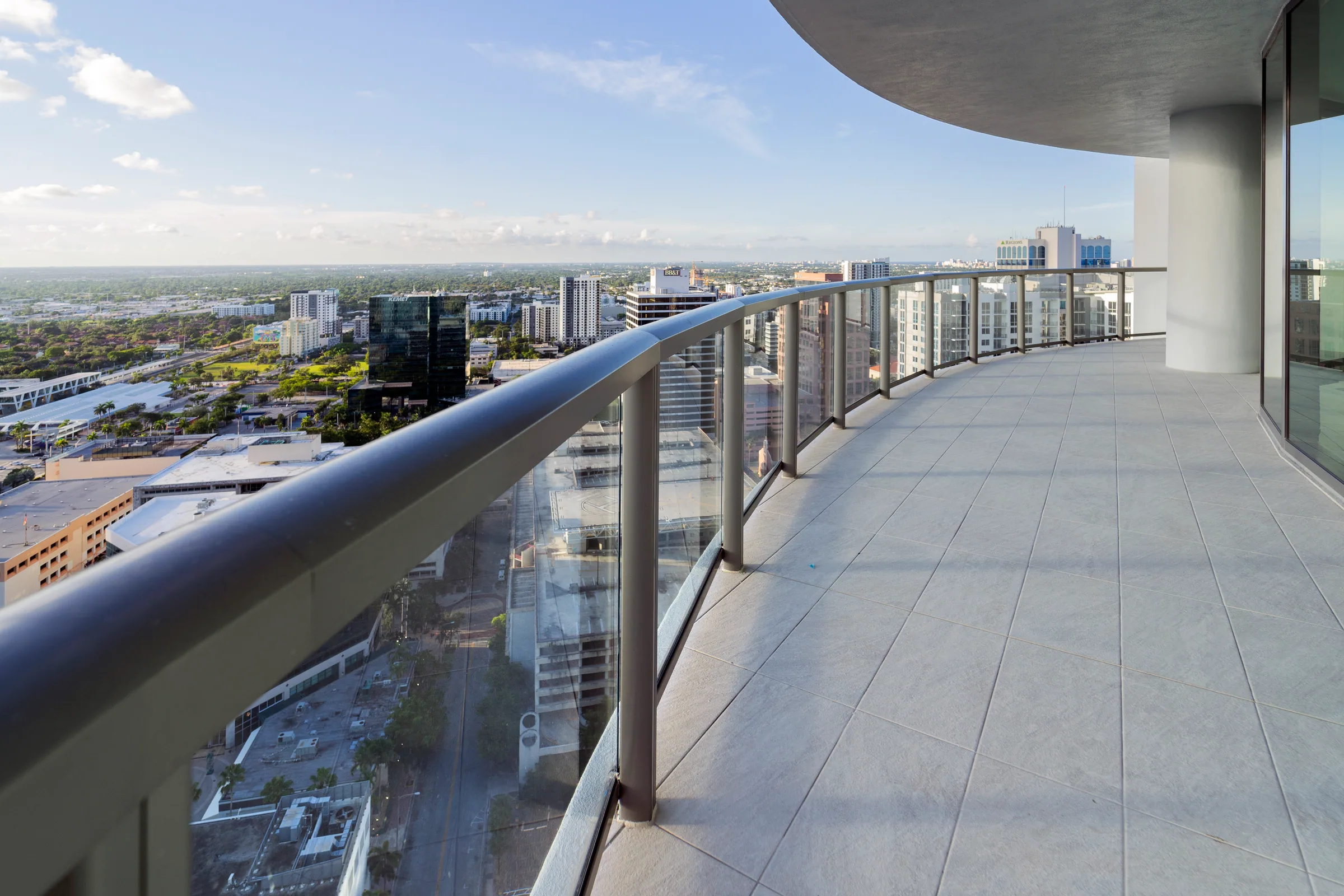 A curved balcony with a glass railing above the city