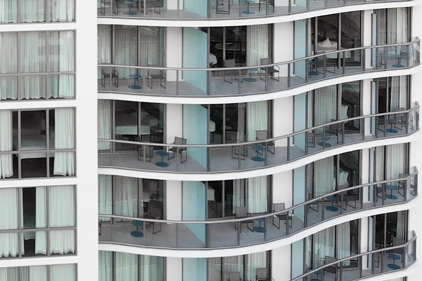 Stacked curved balconies on the white façade