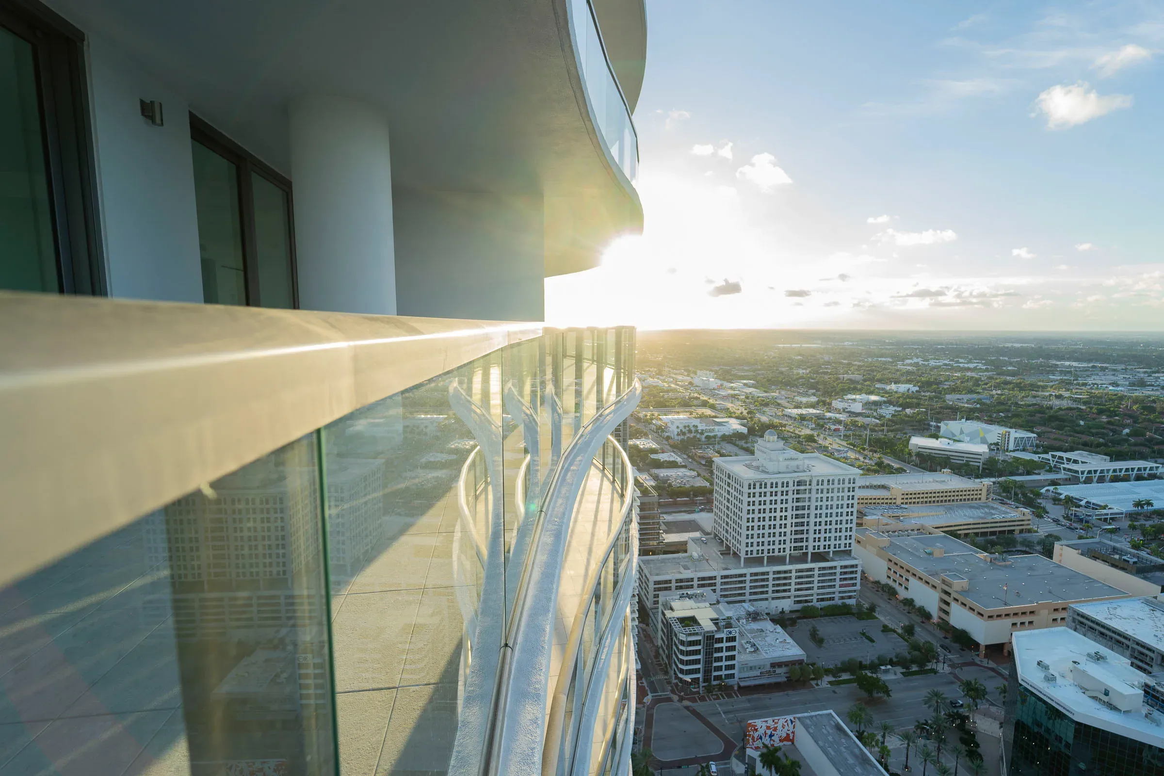 Sun flaring over a glass railing high above Fort Lauderdale