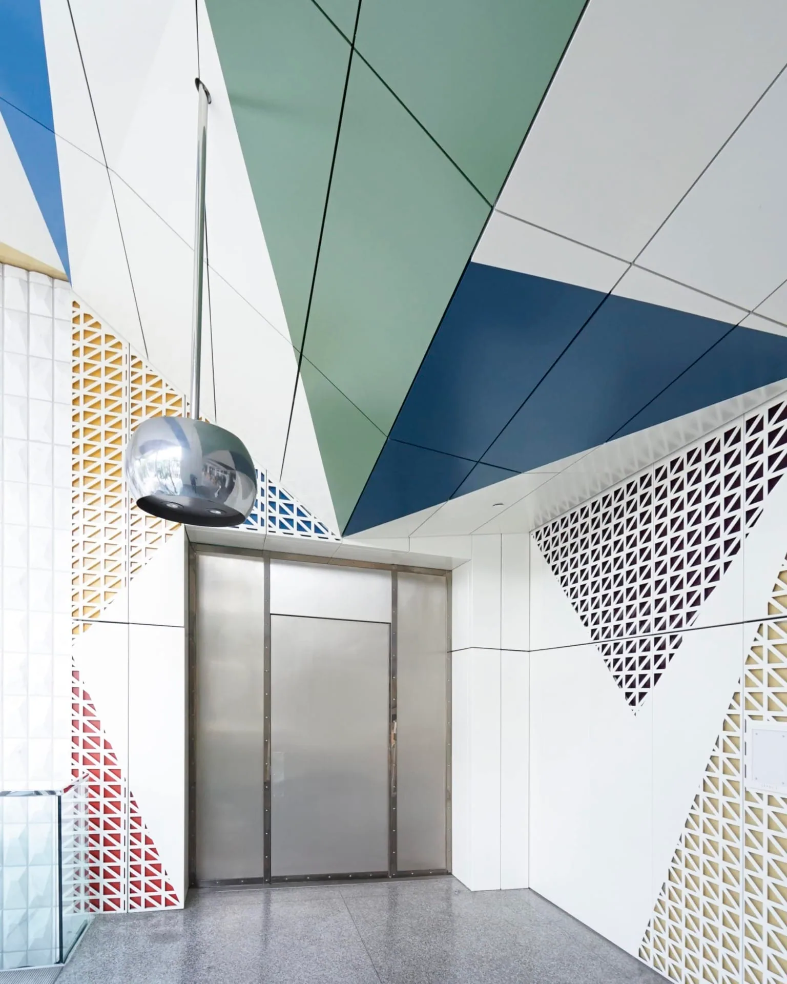 A white entry with a patterned screen and painted ceiling