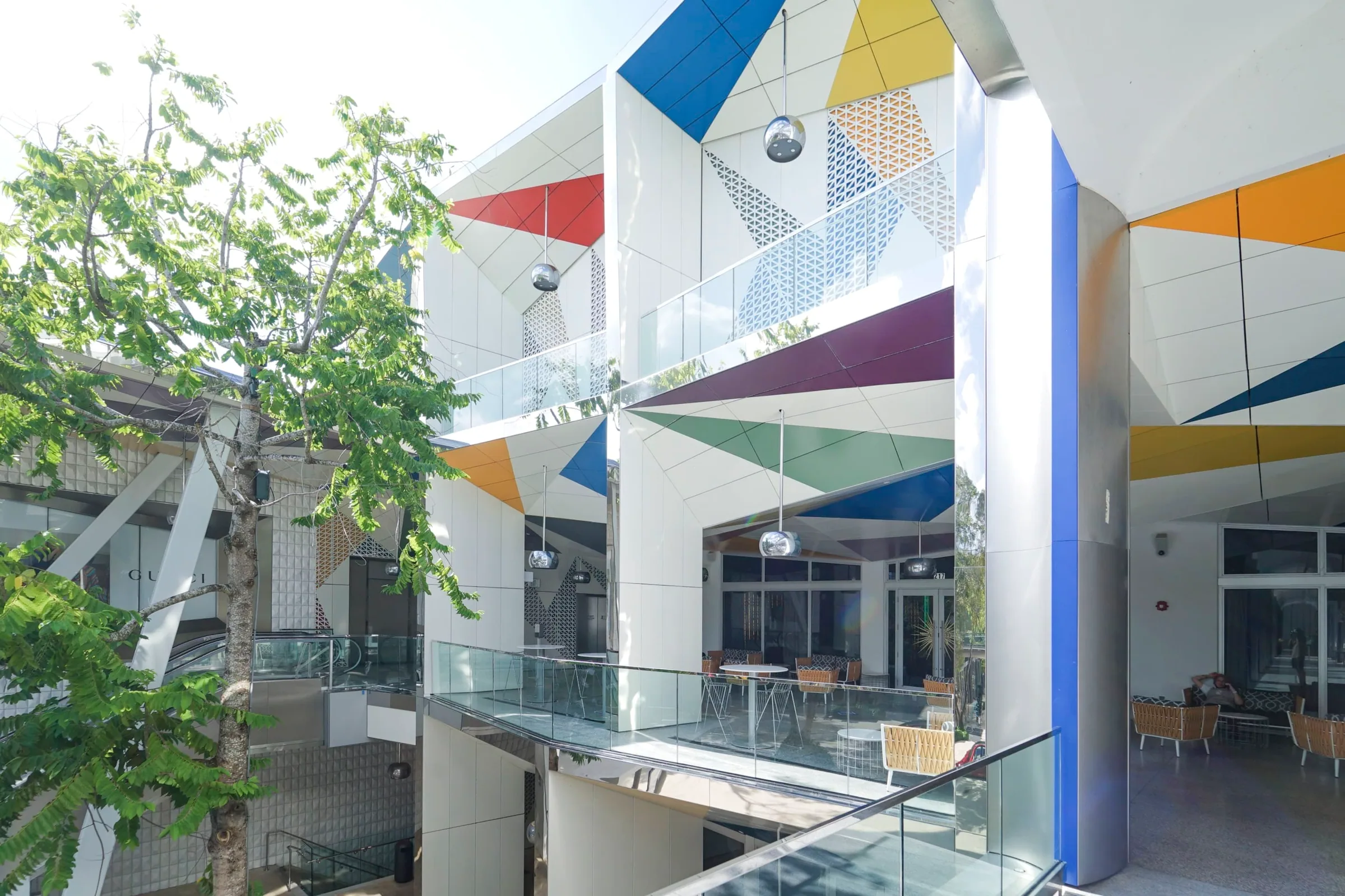 Colored soffits and glass balconies between trees
