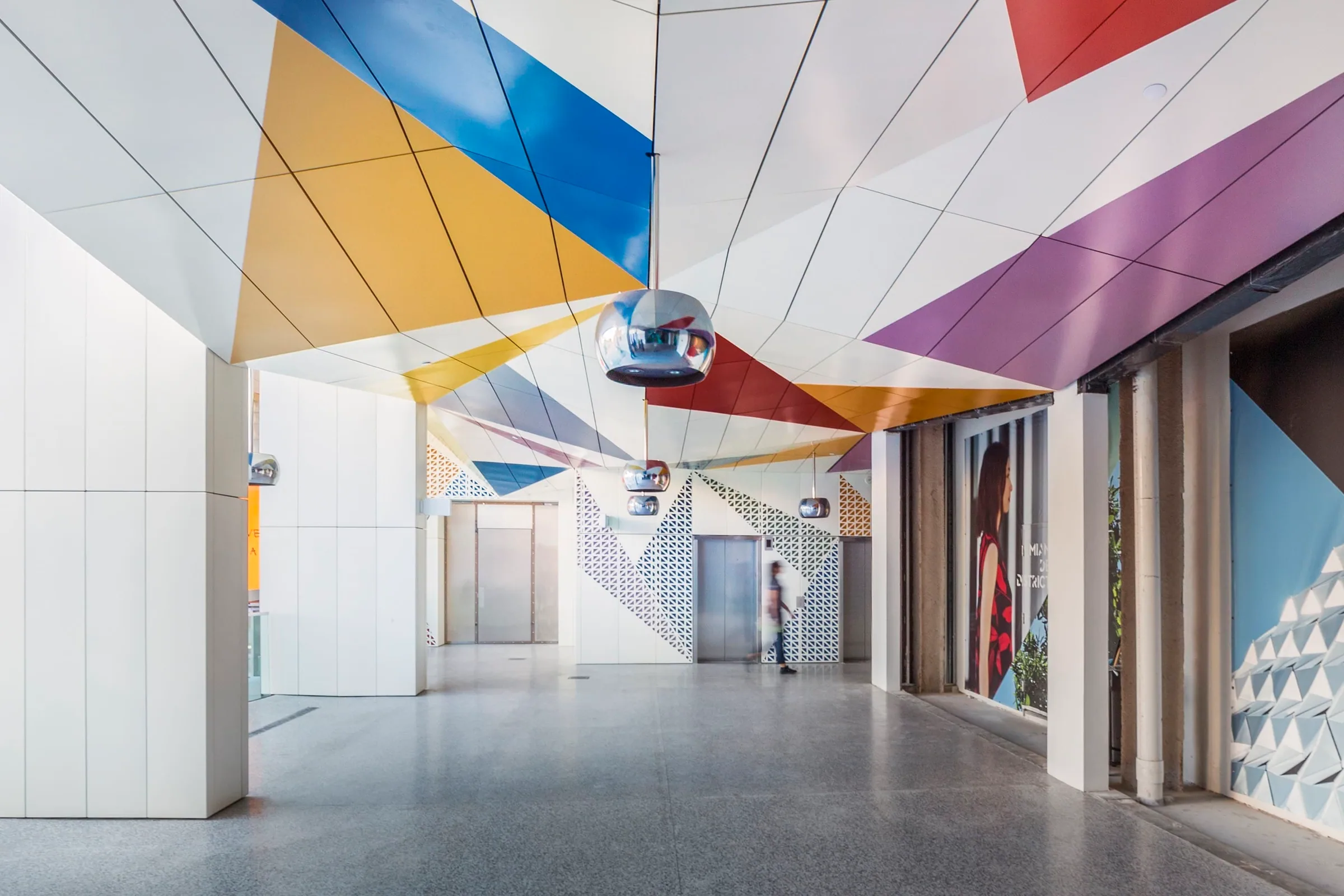 The colored ceiling running down a corridor of shops