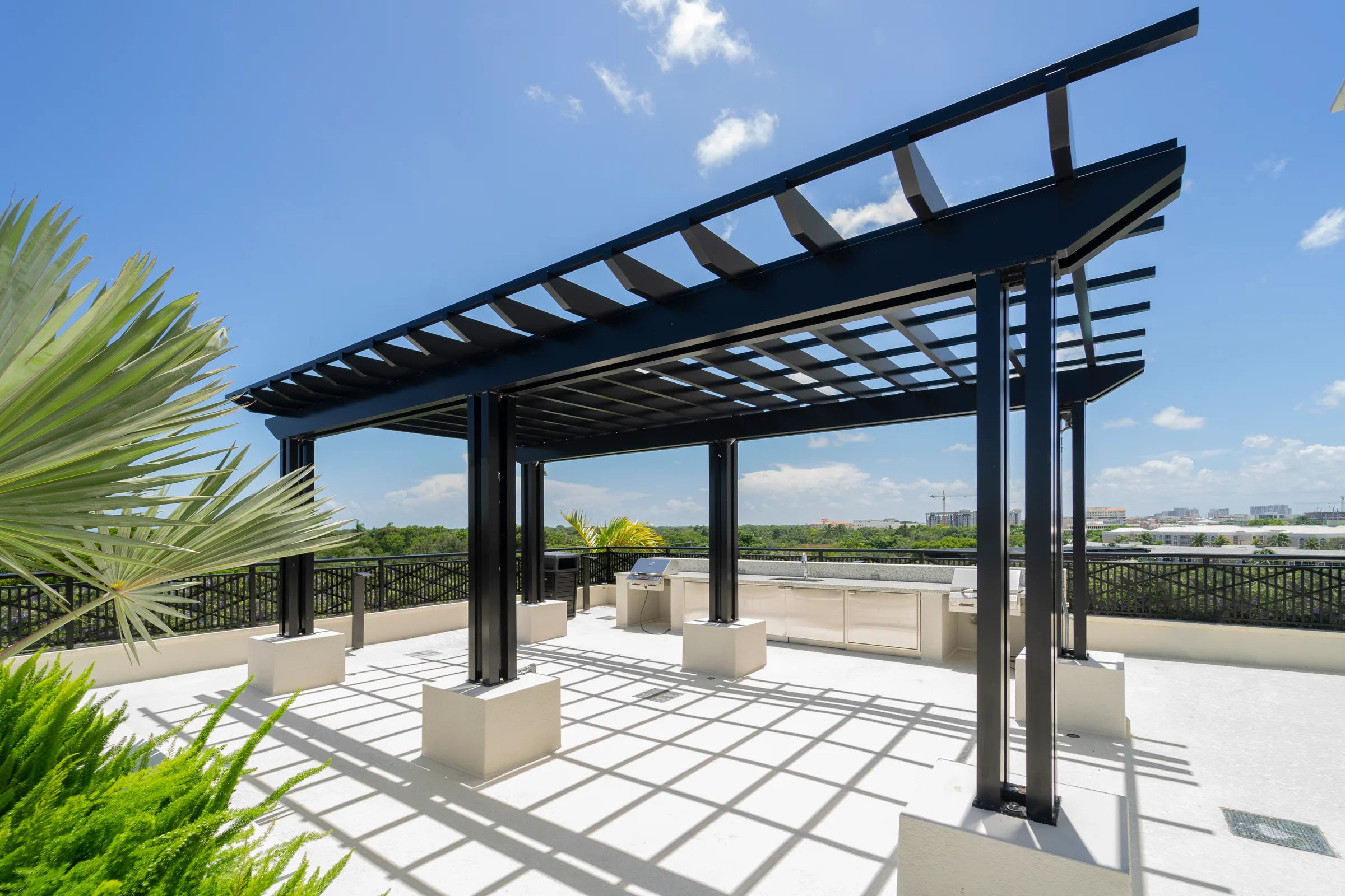 A black steel pergola on a rooftop terrace