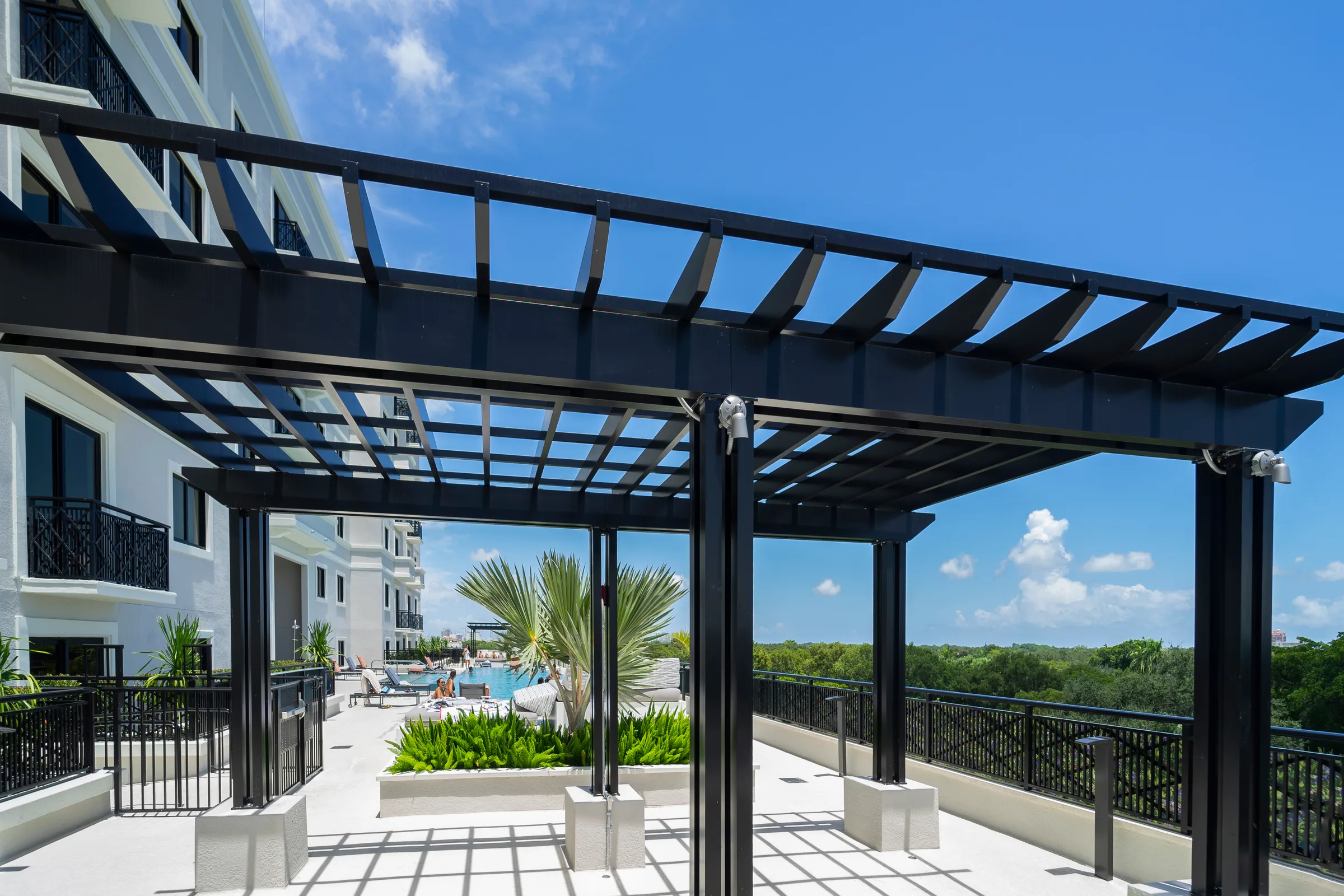 Under the rooftop pergola, palms and railings beyond