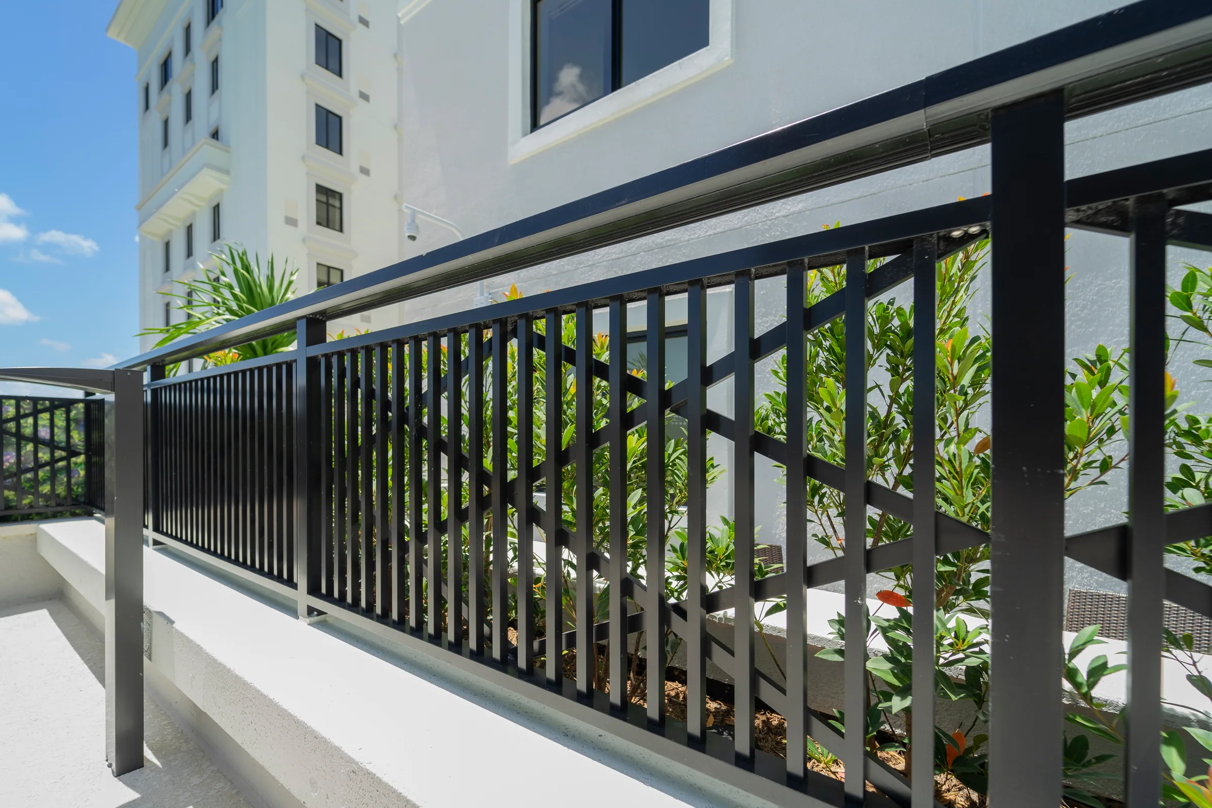 A black picket railing with a patterned panel on a terrace