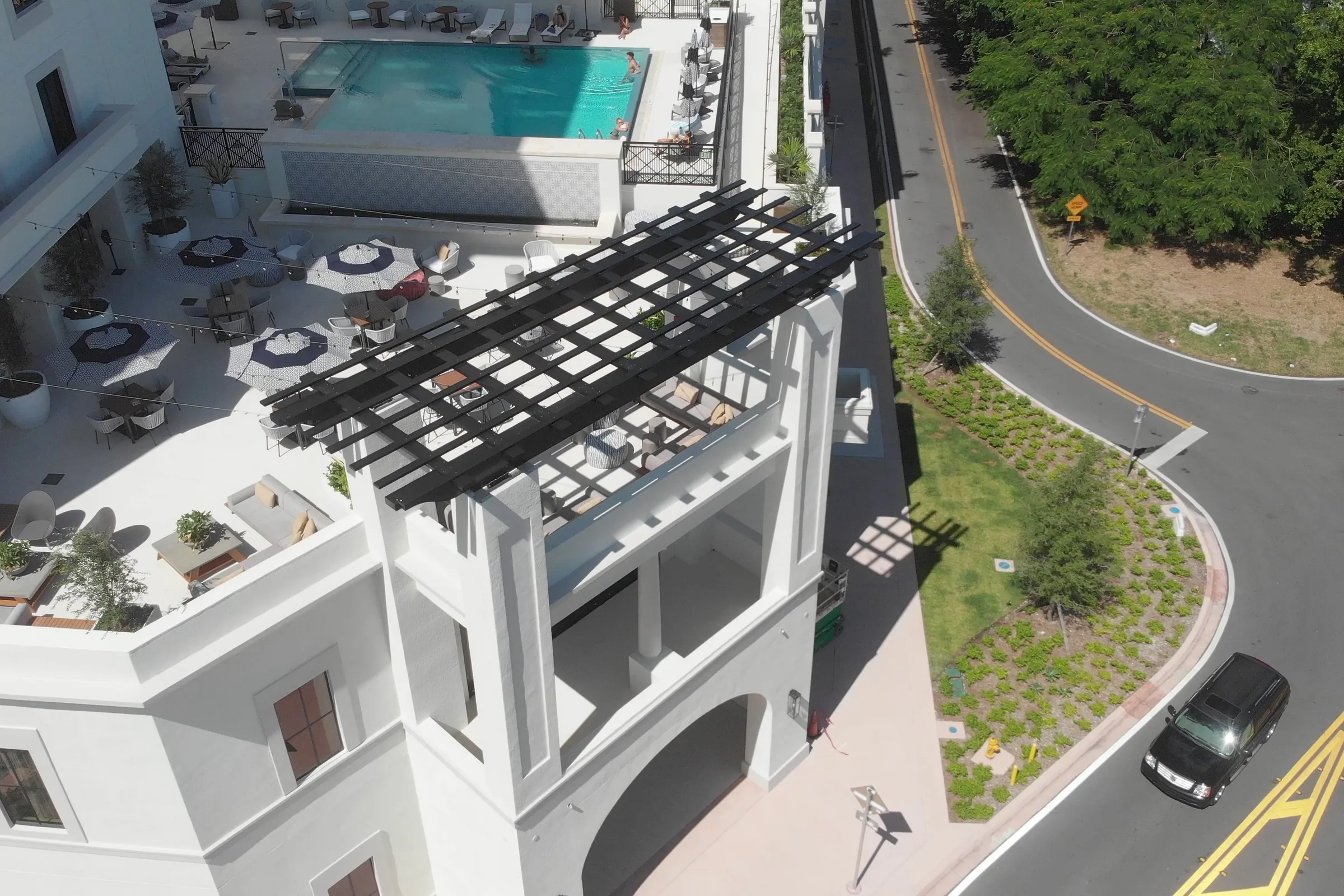 The rooftop pergola and pool above a curving road