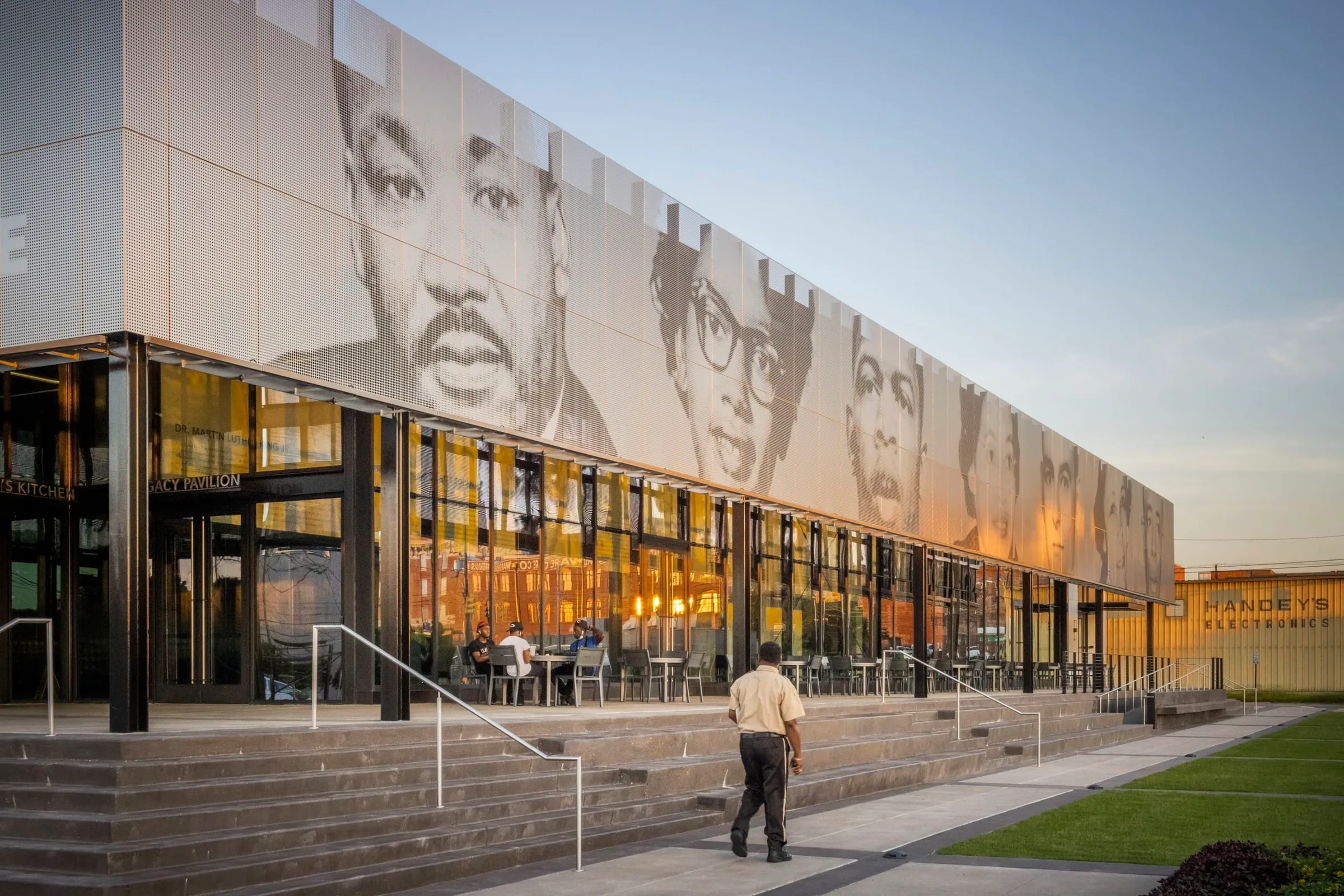 The perforated portraits over the lit patio, a man walking up the steps