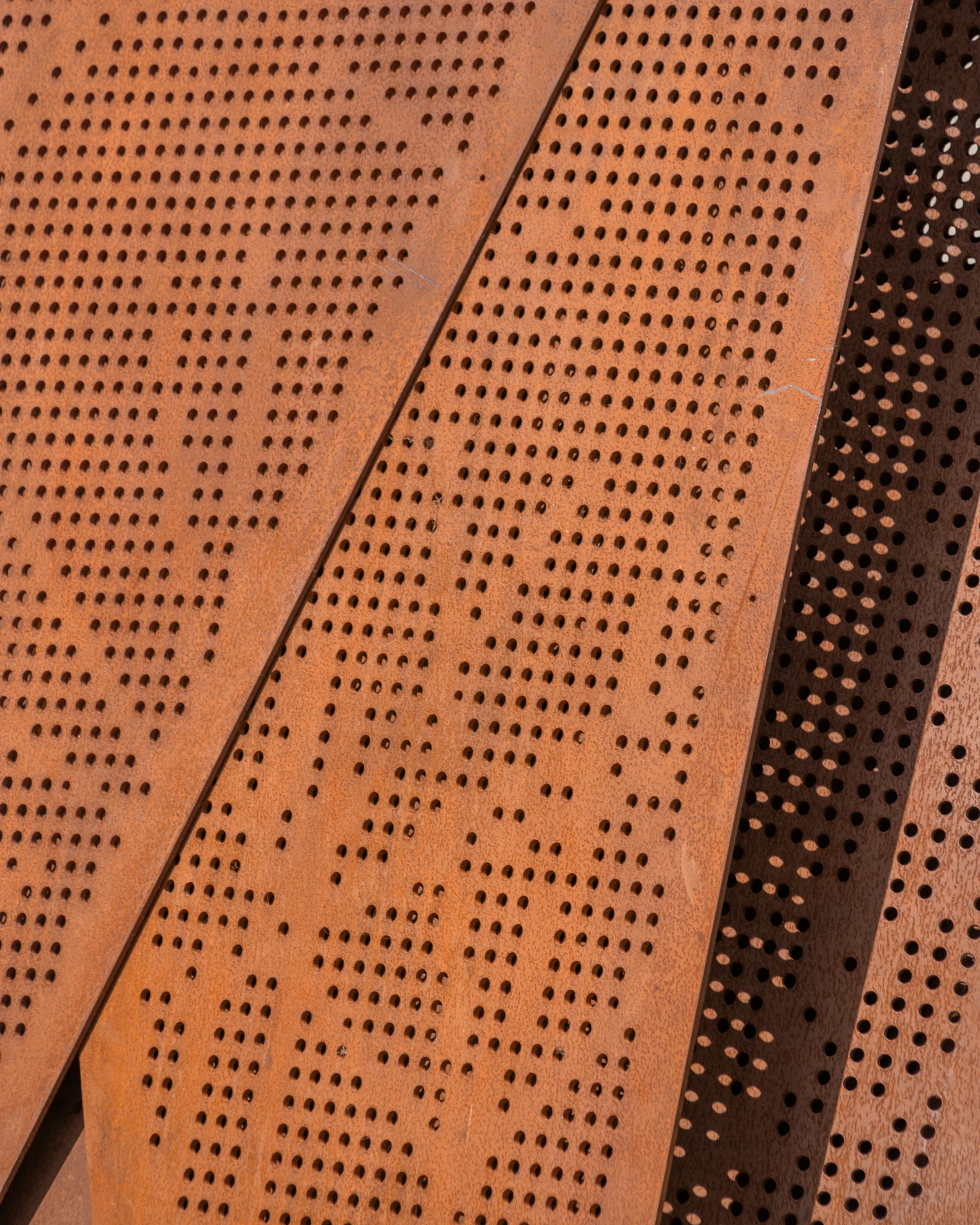 Perforated steel panels with a pattern of small and large holes