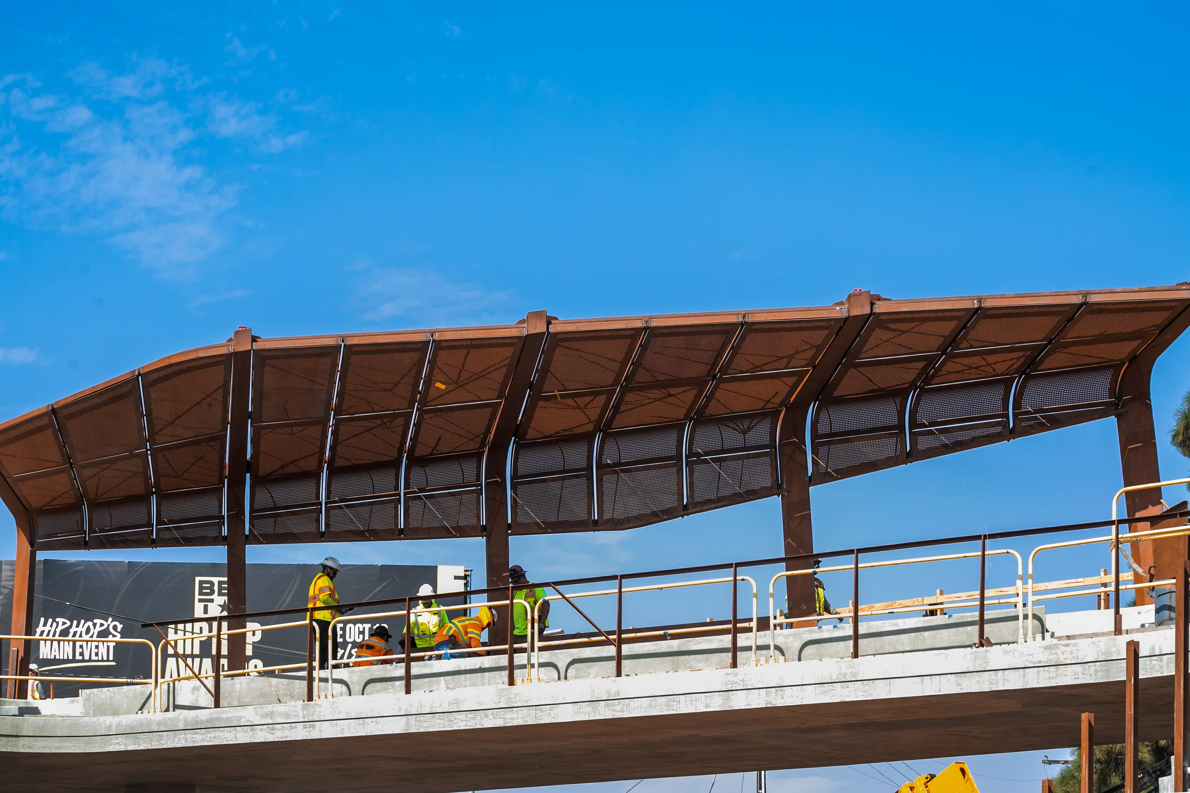 The long perforated canopy over the walkway against a blue sky