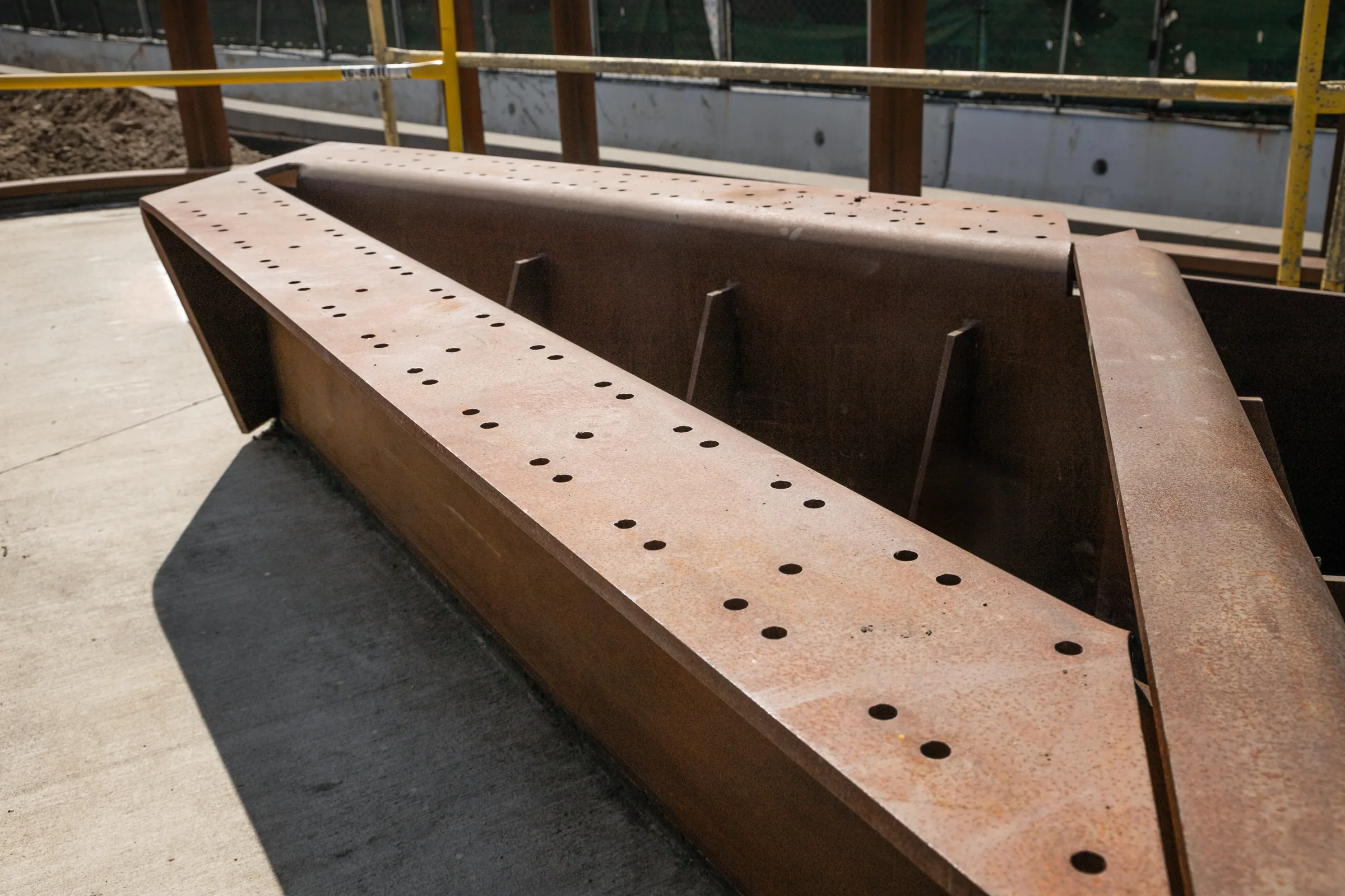 A folded steel planter with a line of bolt holes
