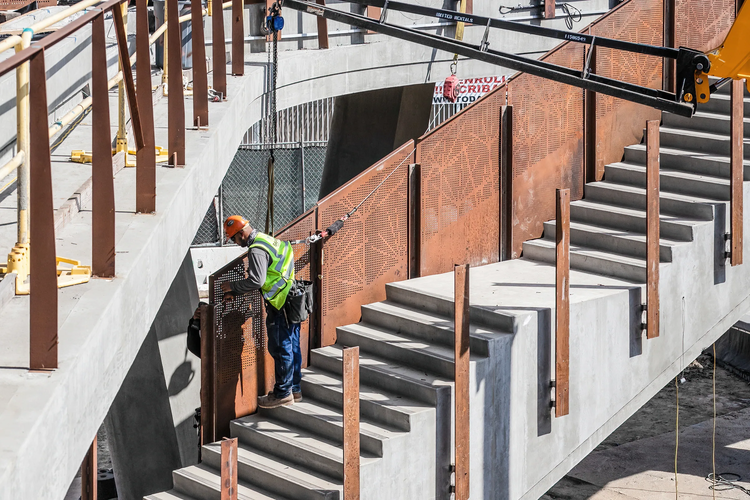 Installers on a stair lined with perforated steel guards