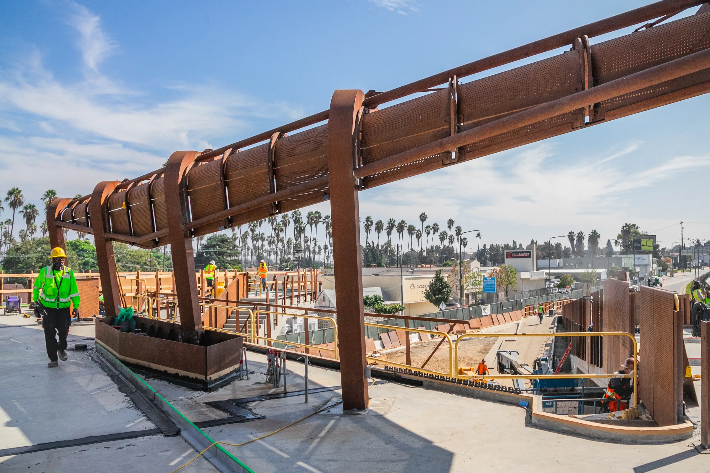 Steel beams and posts over the walkway as crews work below