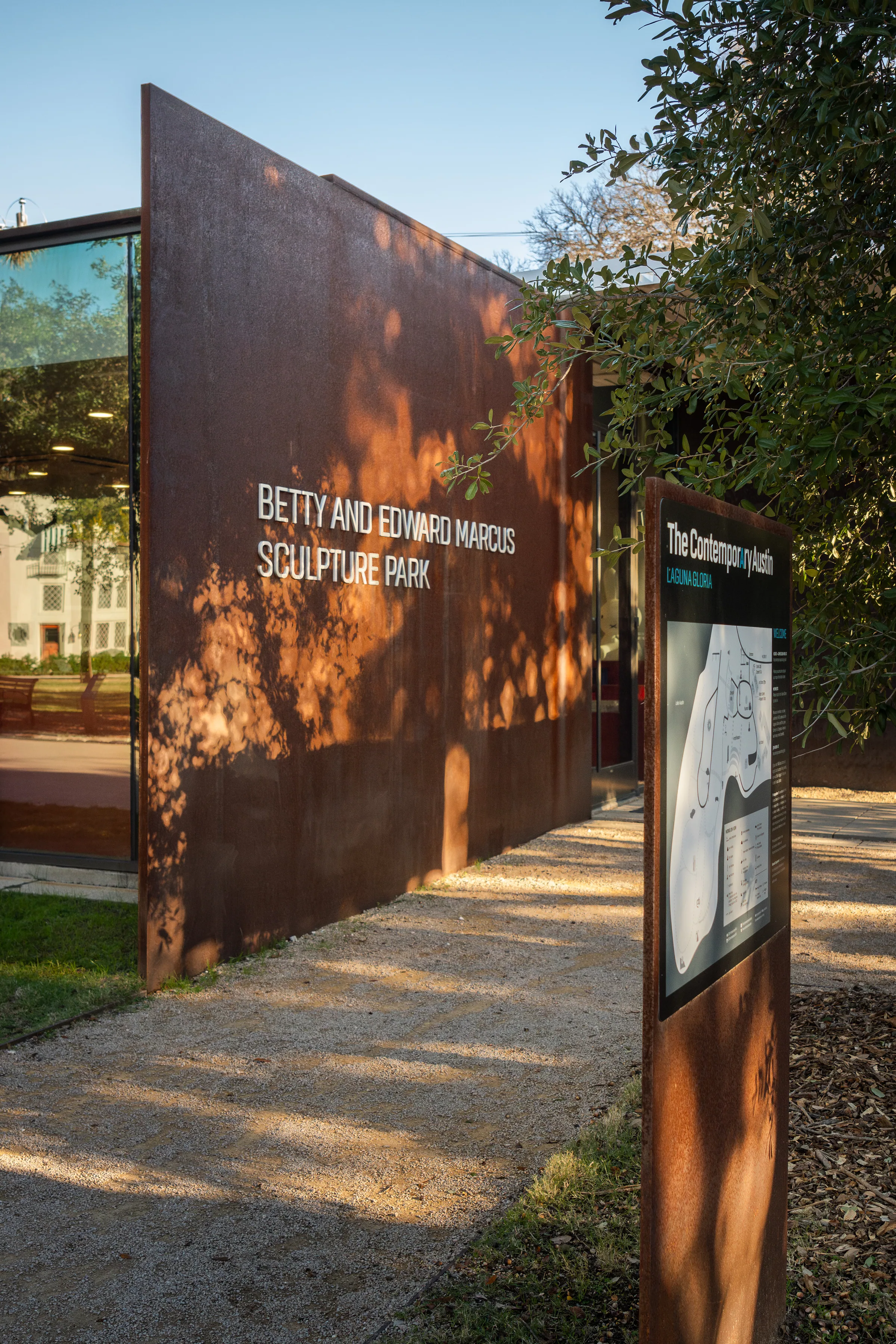 The lettered wall and a sign along the gravel path