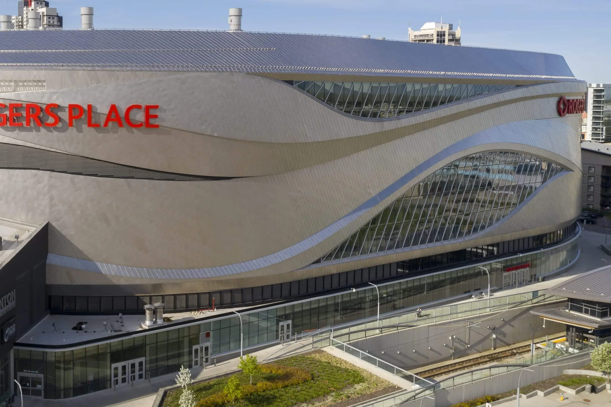 Close on the façade: metal bands wave over a long ribbon of glass