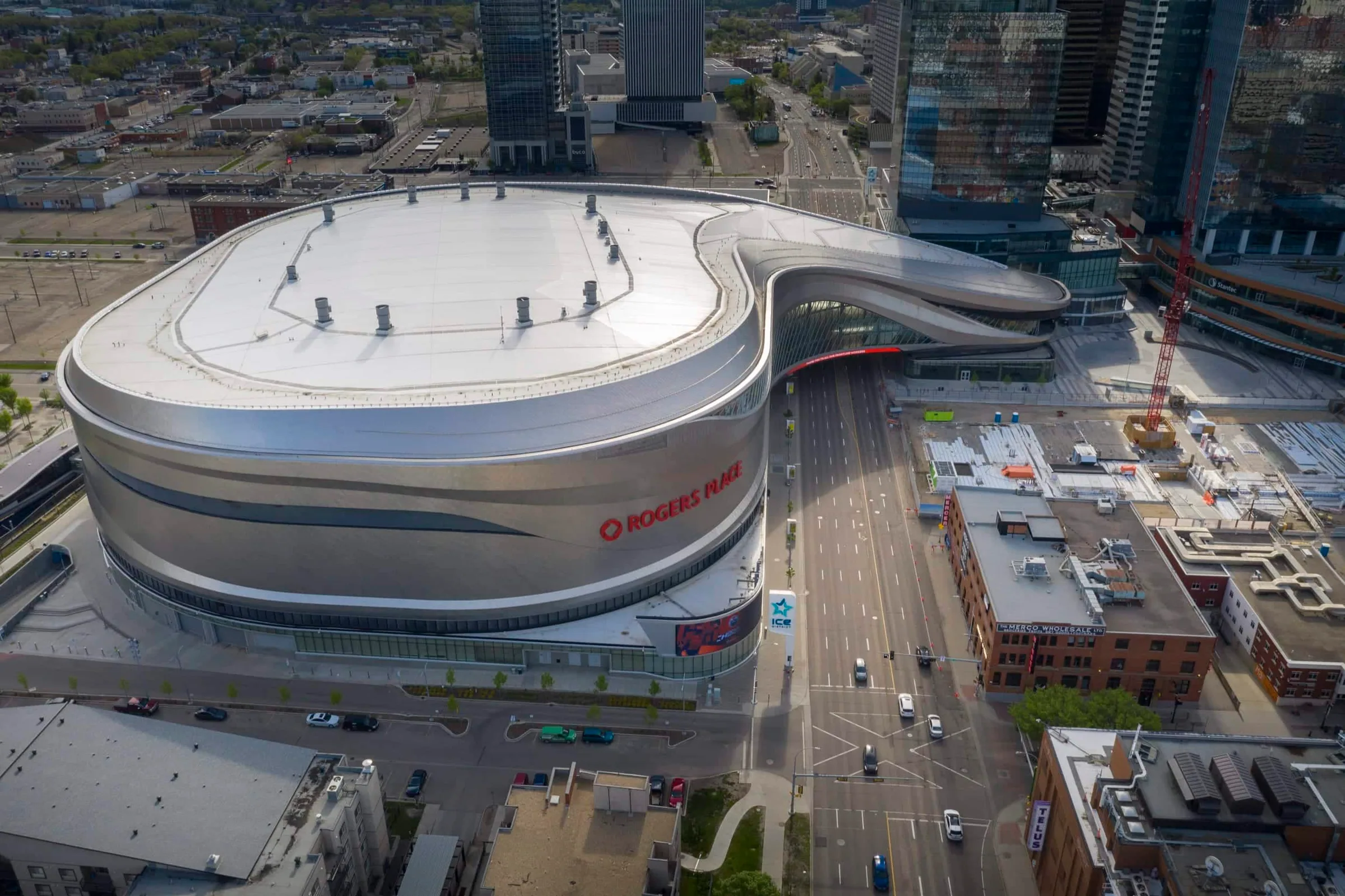 From high above: the arena’s white roof and silver walls sweeping over the street into downtown