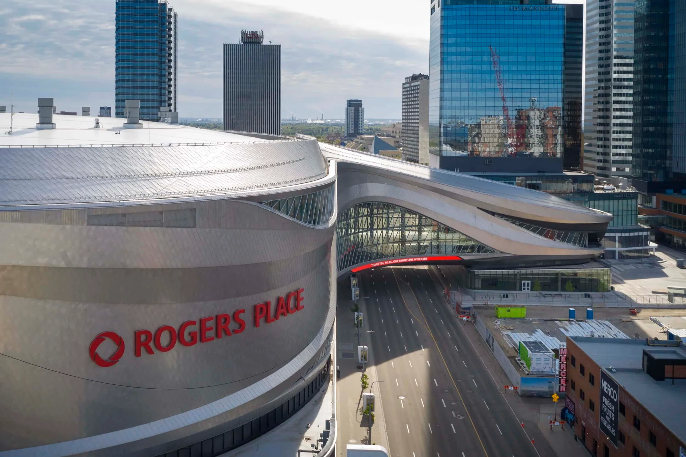 The Rogers Place sign on the metal wall, a glass-sided bridge spanning the street beside it