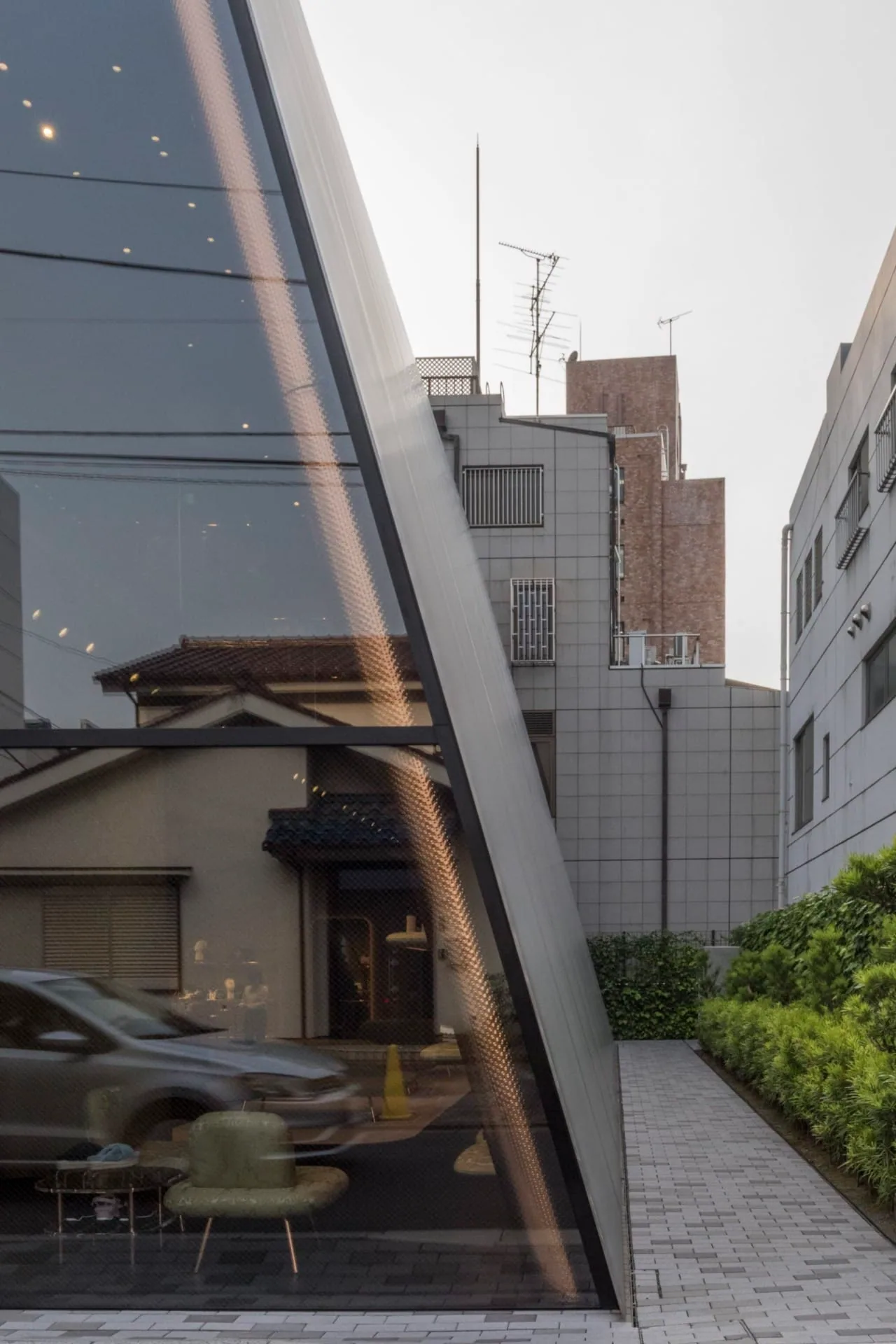 The glass edge of the fold reflecting the house next door