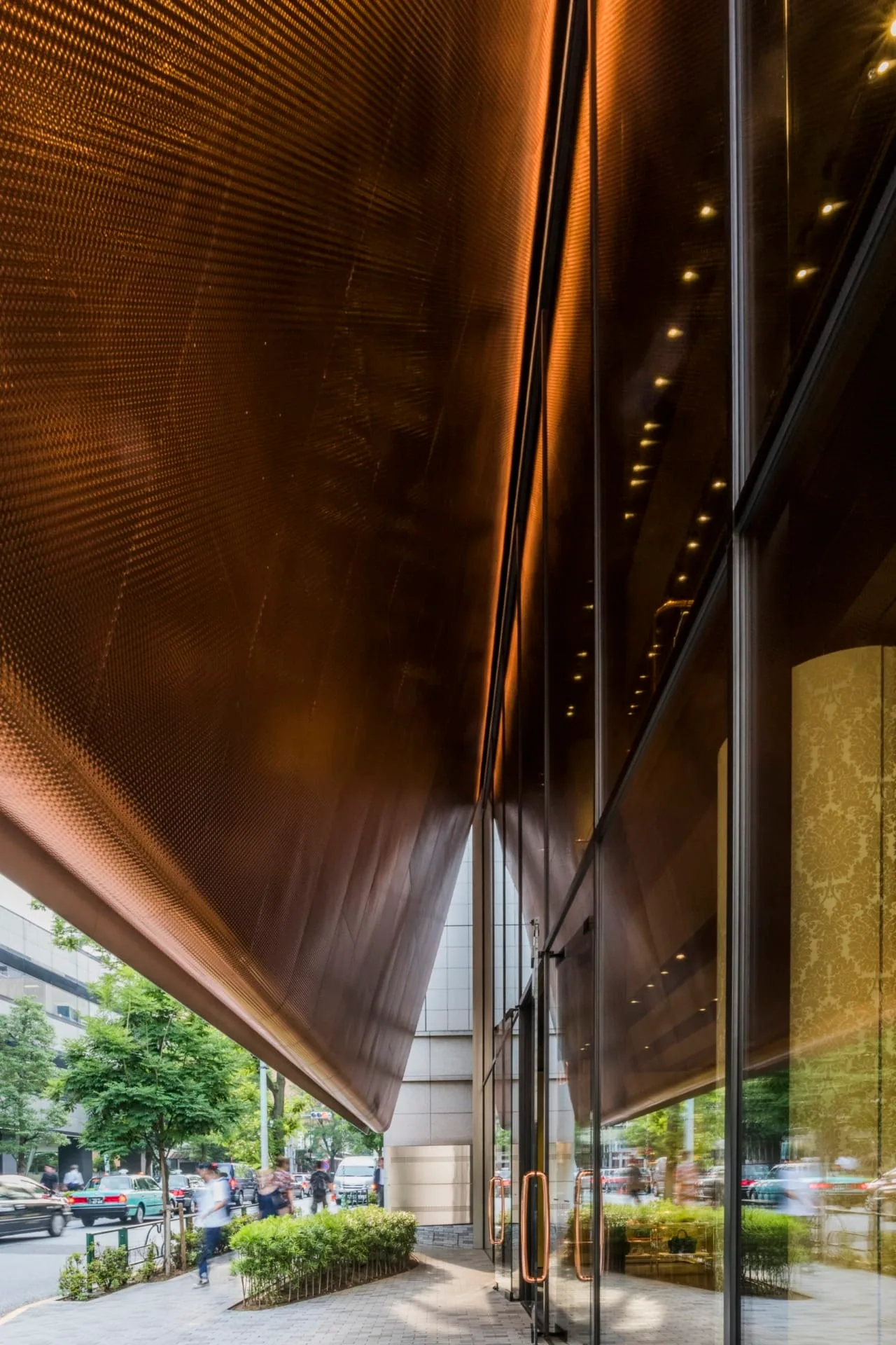 Looking along the sidewalk under the copper underside