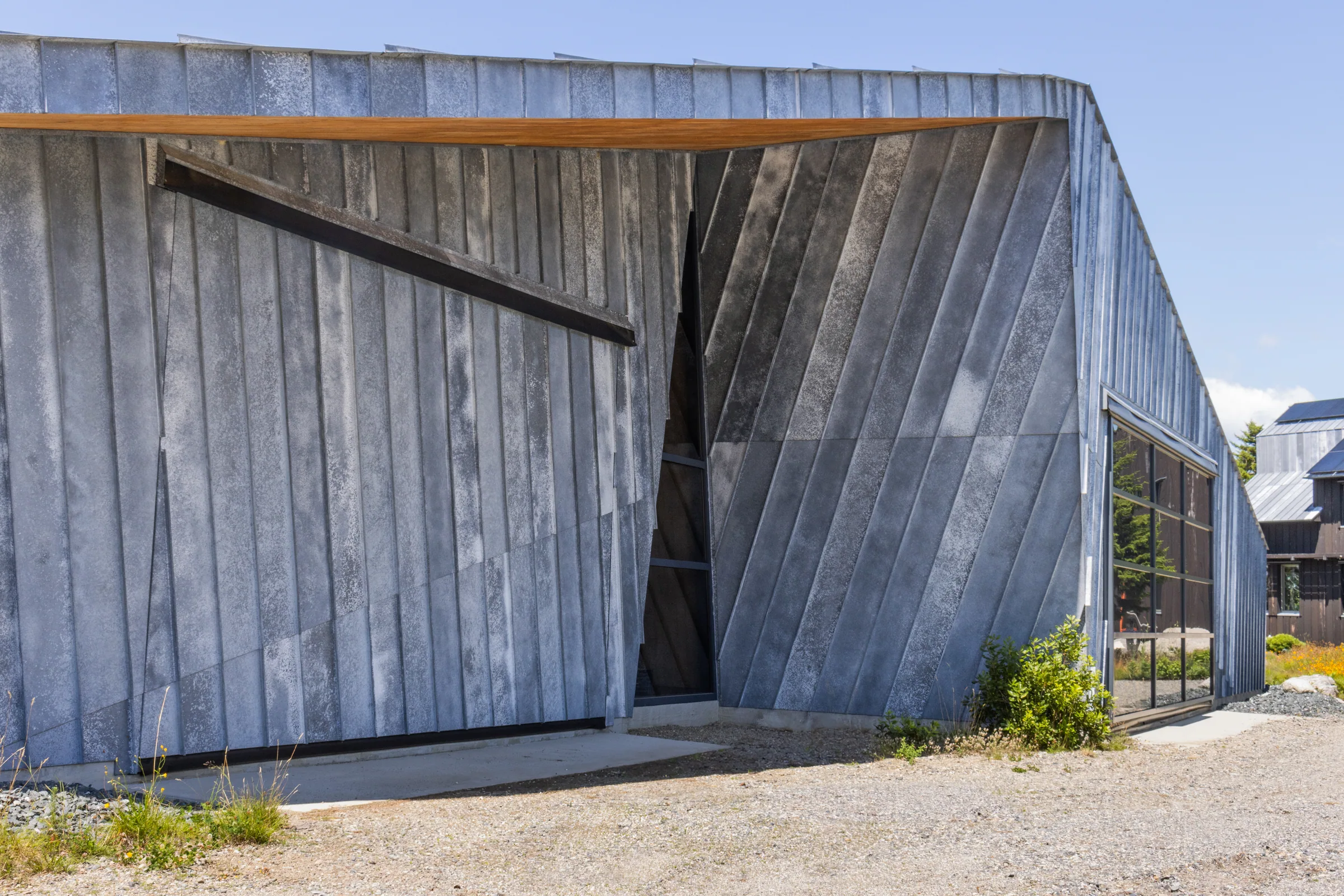 The zinc studio’s tall cut-in entry from the gravel yard