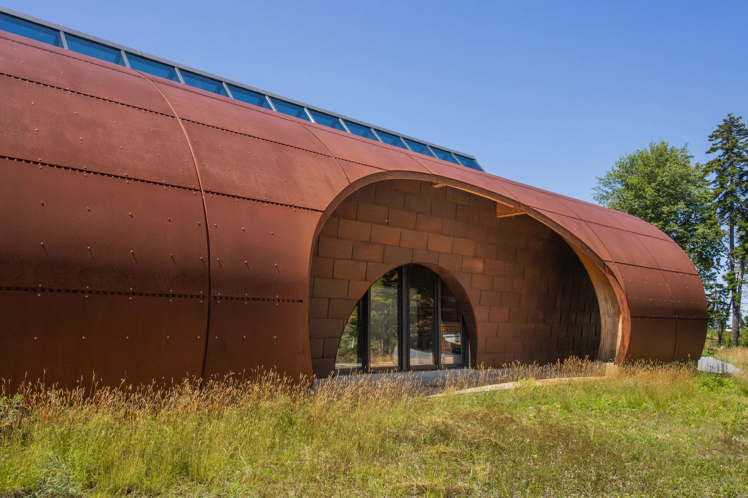 The arched steel building in a meadow, its round entry open