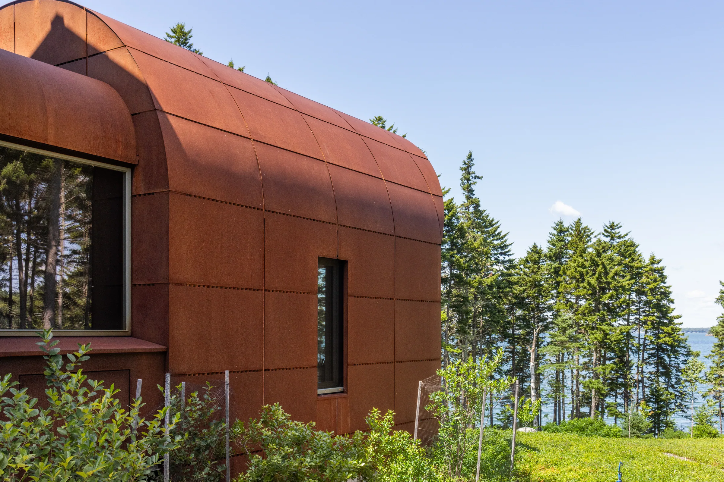 A weathering steel wing among spruce trees