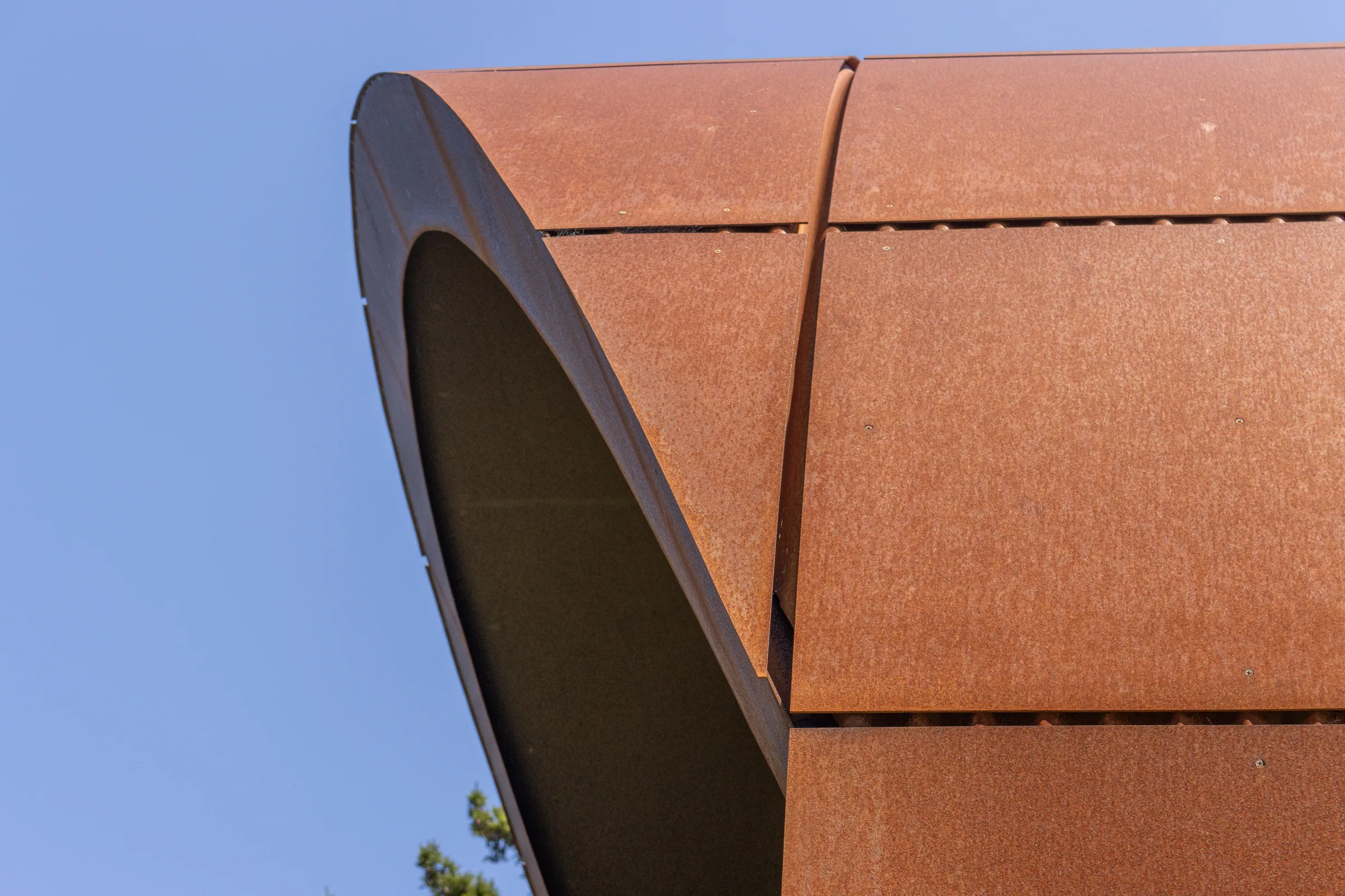 The curved edge of the steel vault against a blue sky