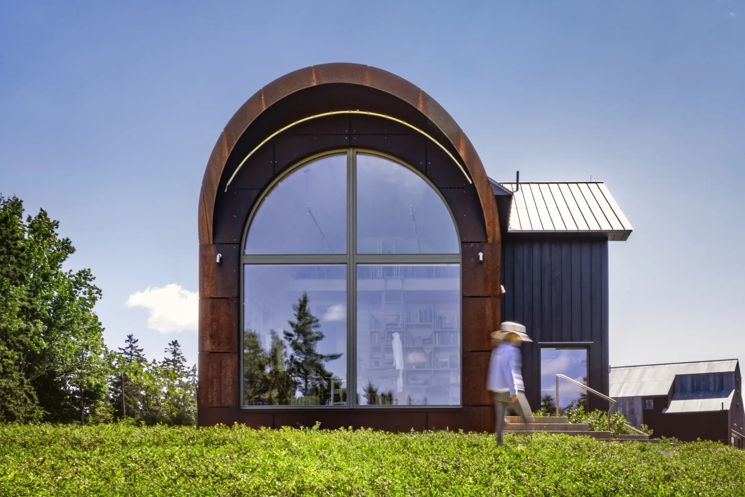 A visitor walking past the arched window