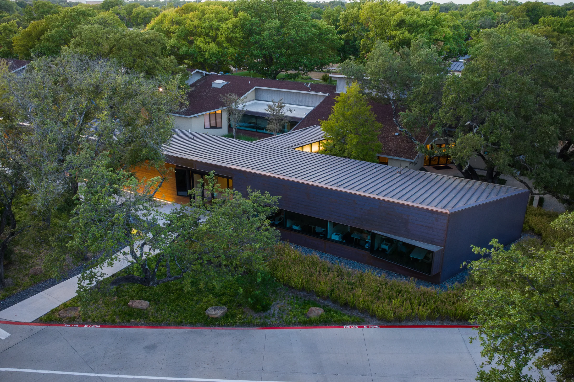 From above: a long copper-clad building among trees