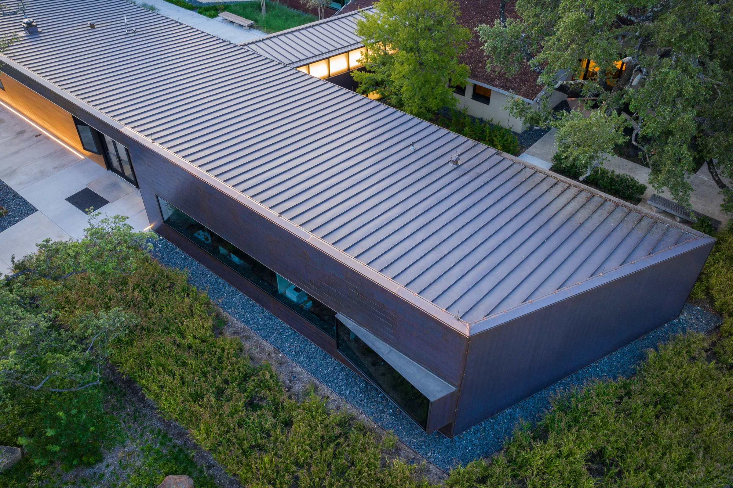 From above: a long ribbed roof running beside a garden