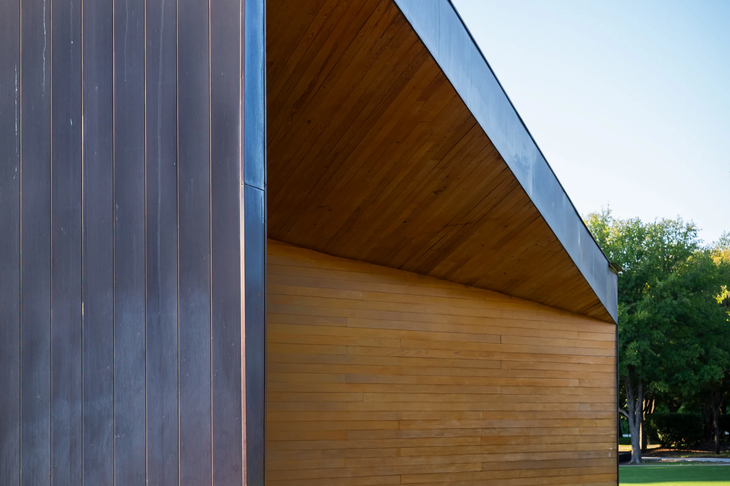 Where the dark copper wall meets the wood soffit