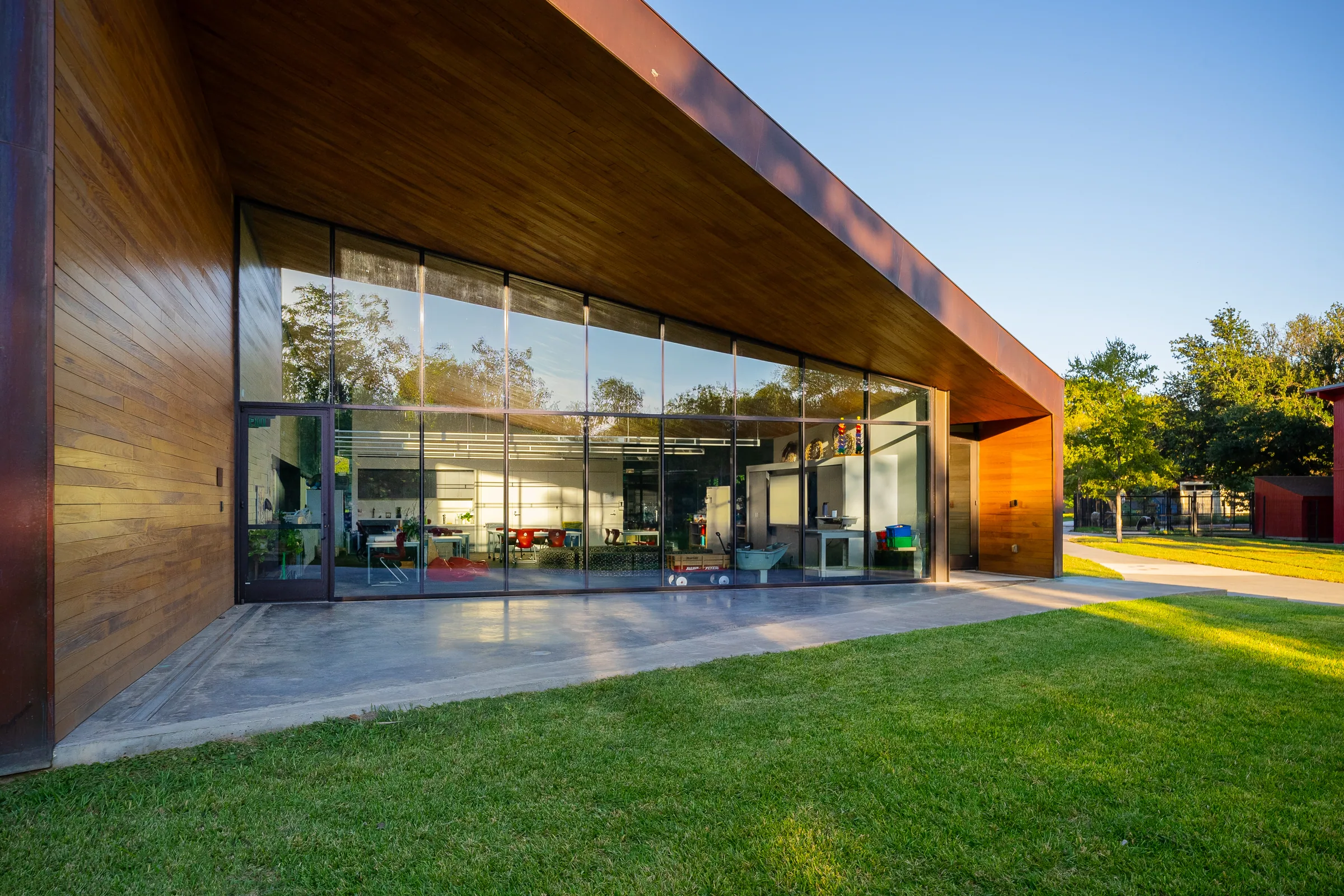 Floor-to-ceiling glass under a copper and wood overhang