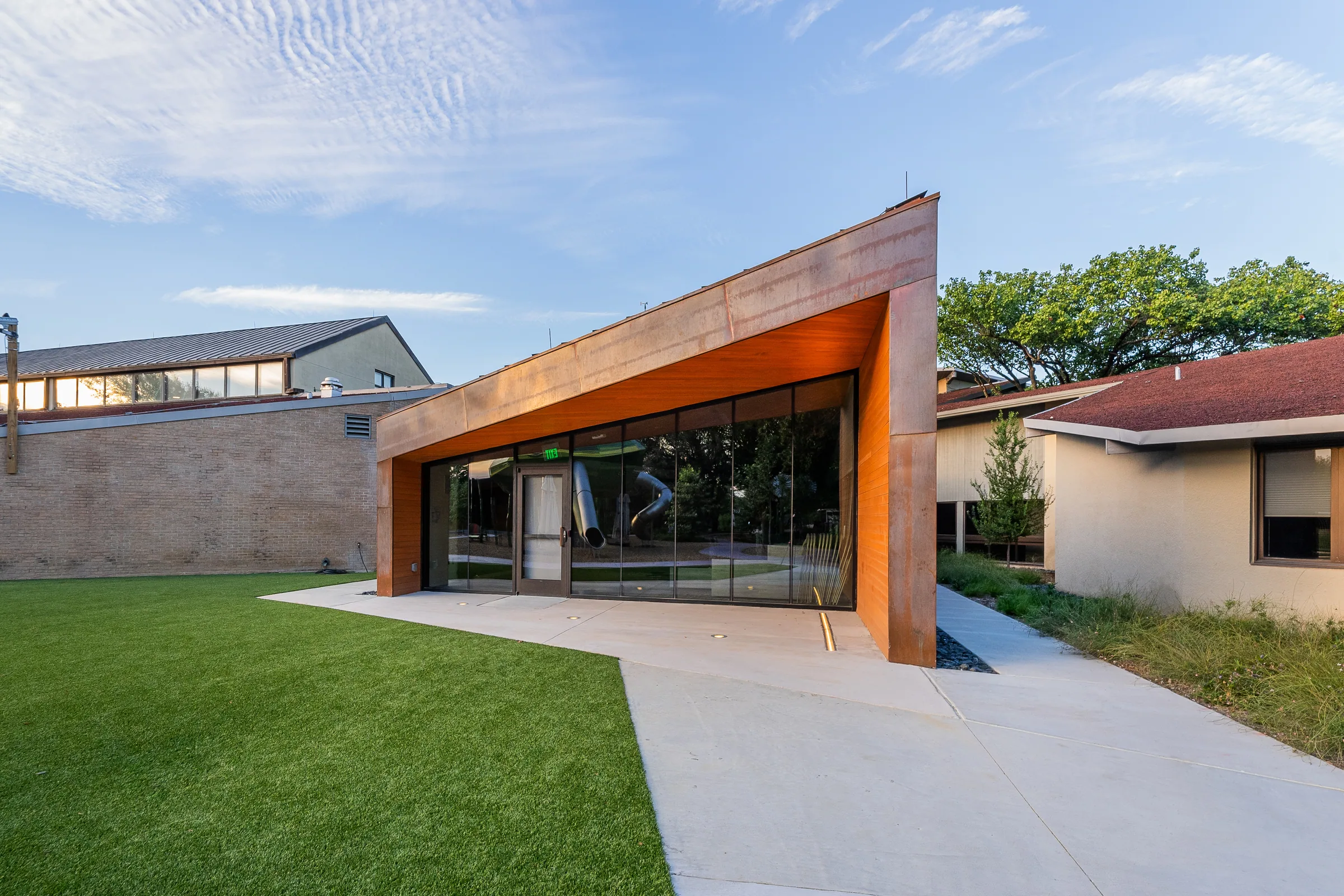 The angled copper entry facing a courtyard lawn