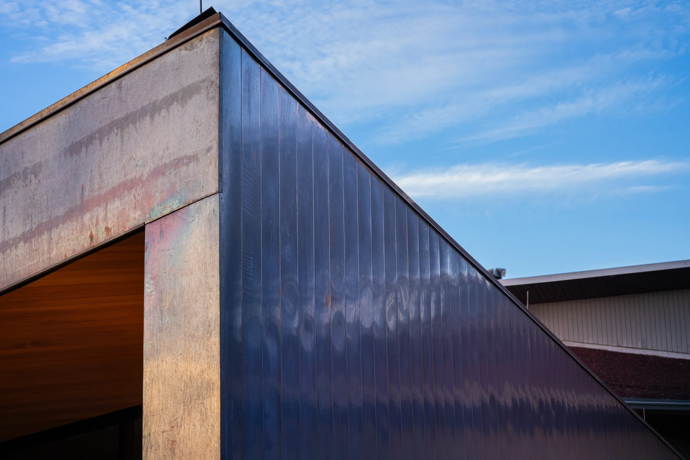 The angled corner of a copper building against the sky
