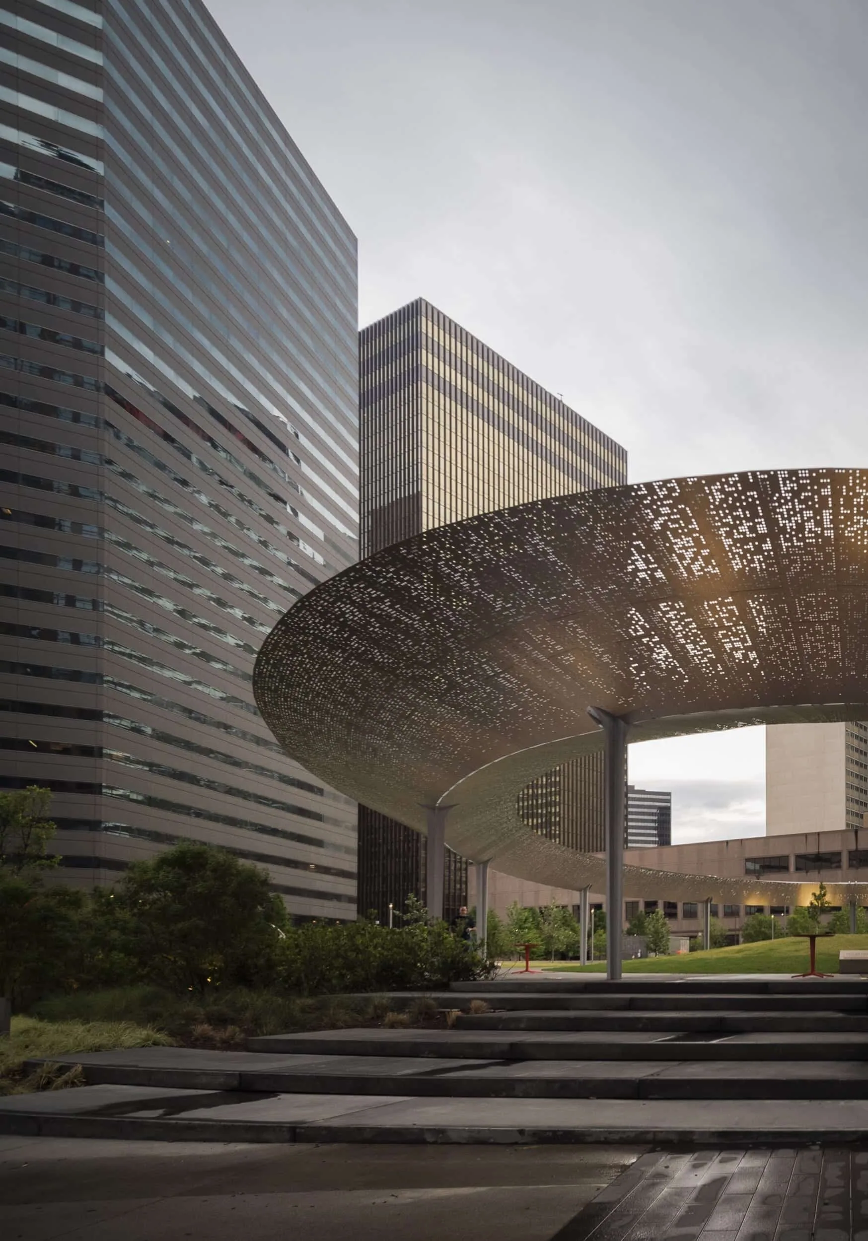 The pavilion's perforated canopy between downtown towers