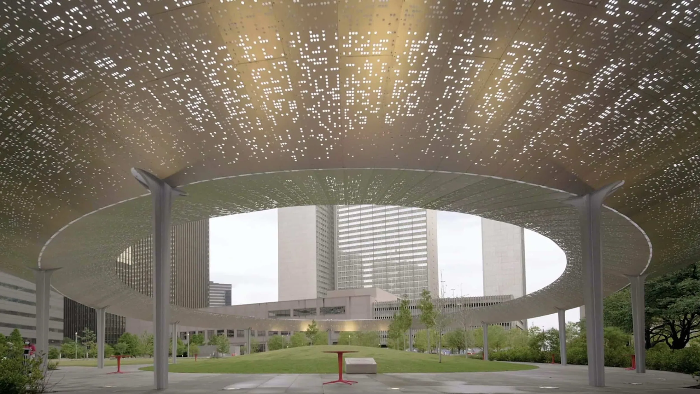 Light through the perforated pavilion roof, towers beyond