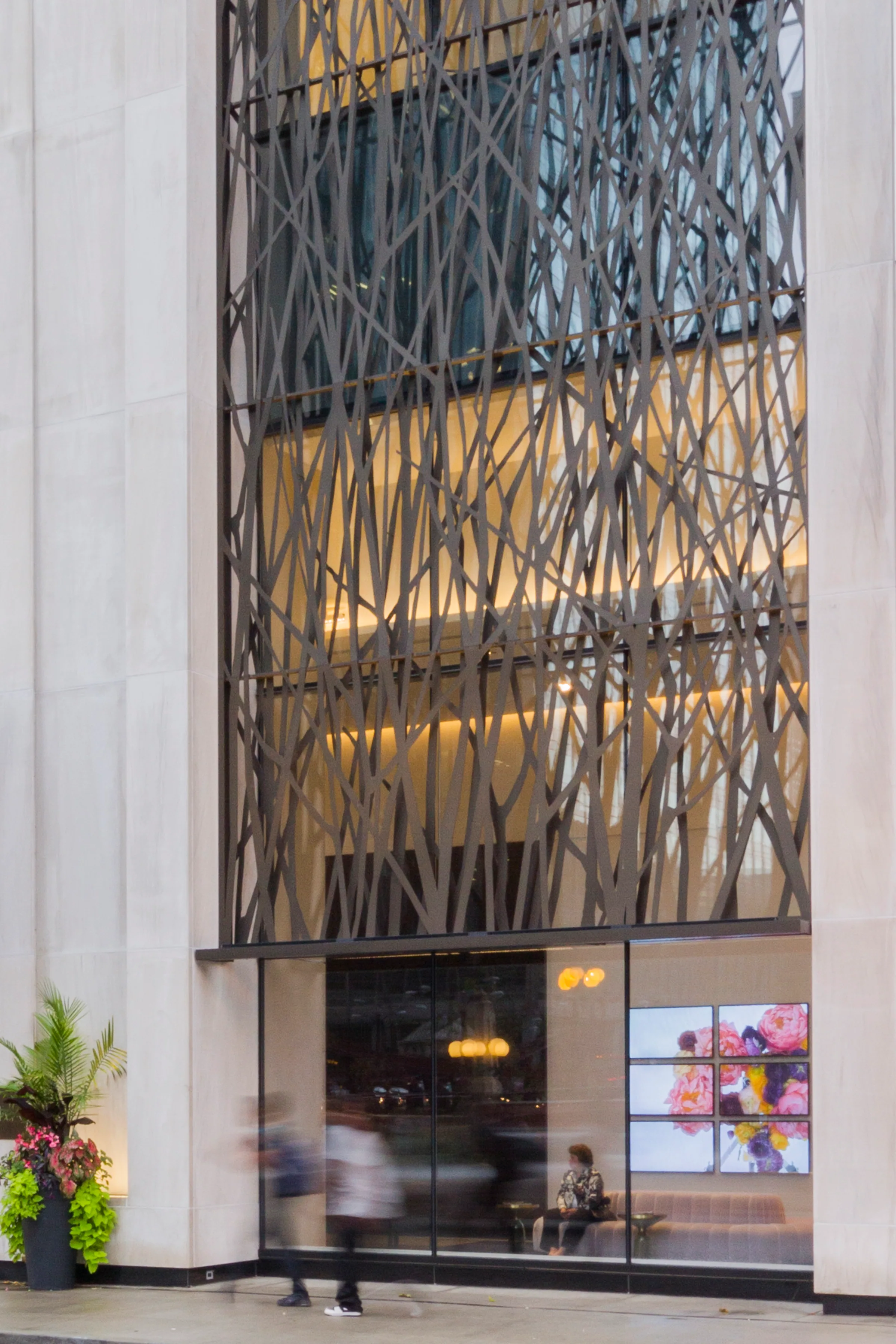 Close on the branching perforated panel, warm light behind it