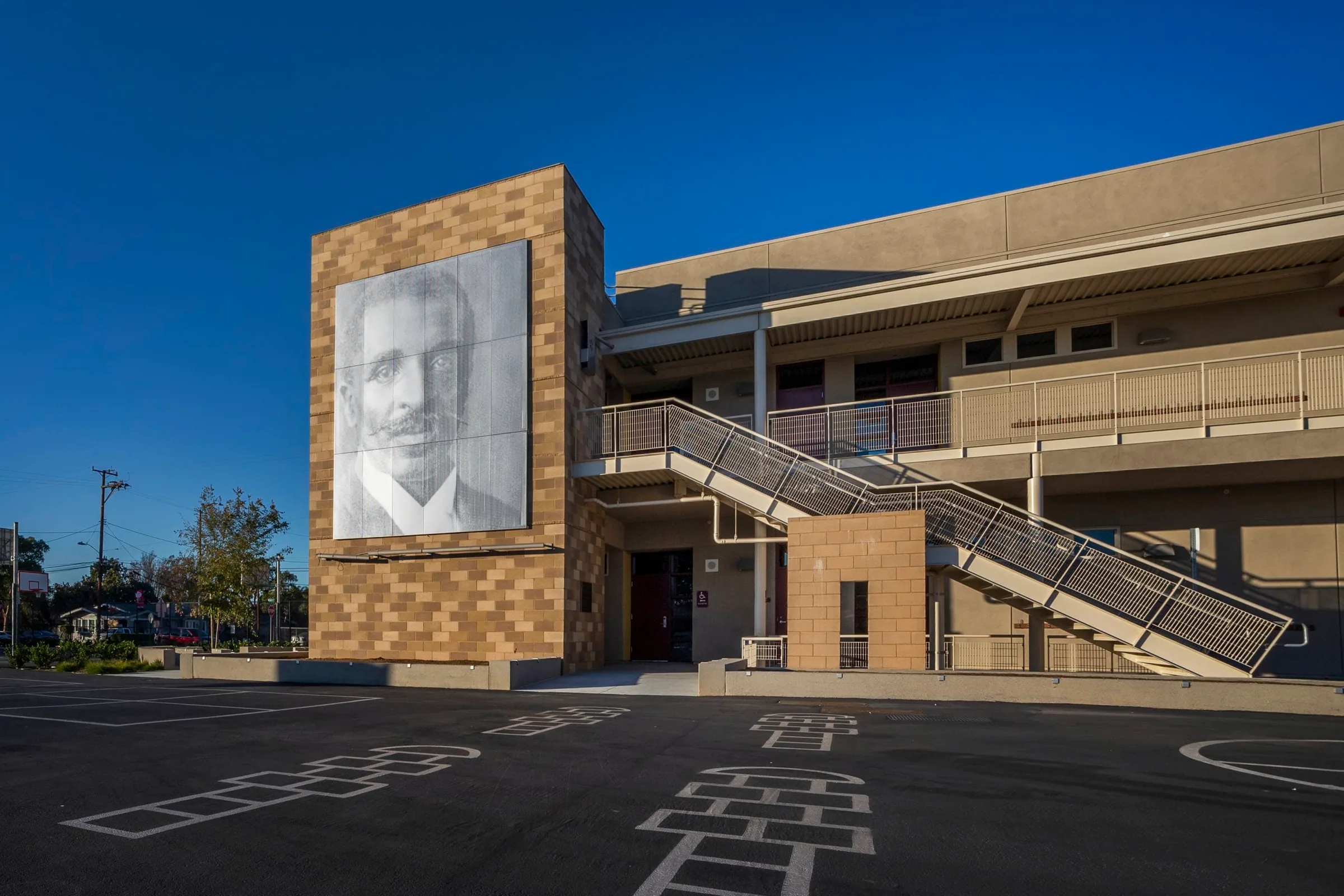 The portrait mural on a block tower beside the classroom stair