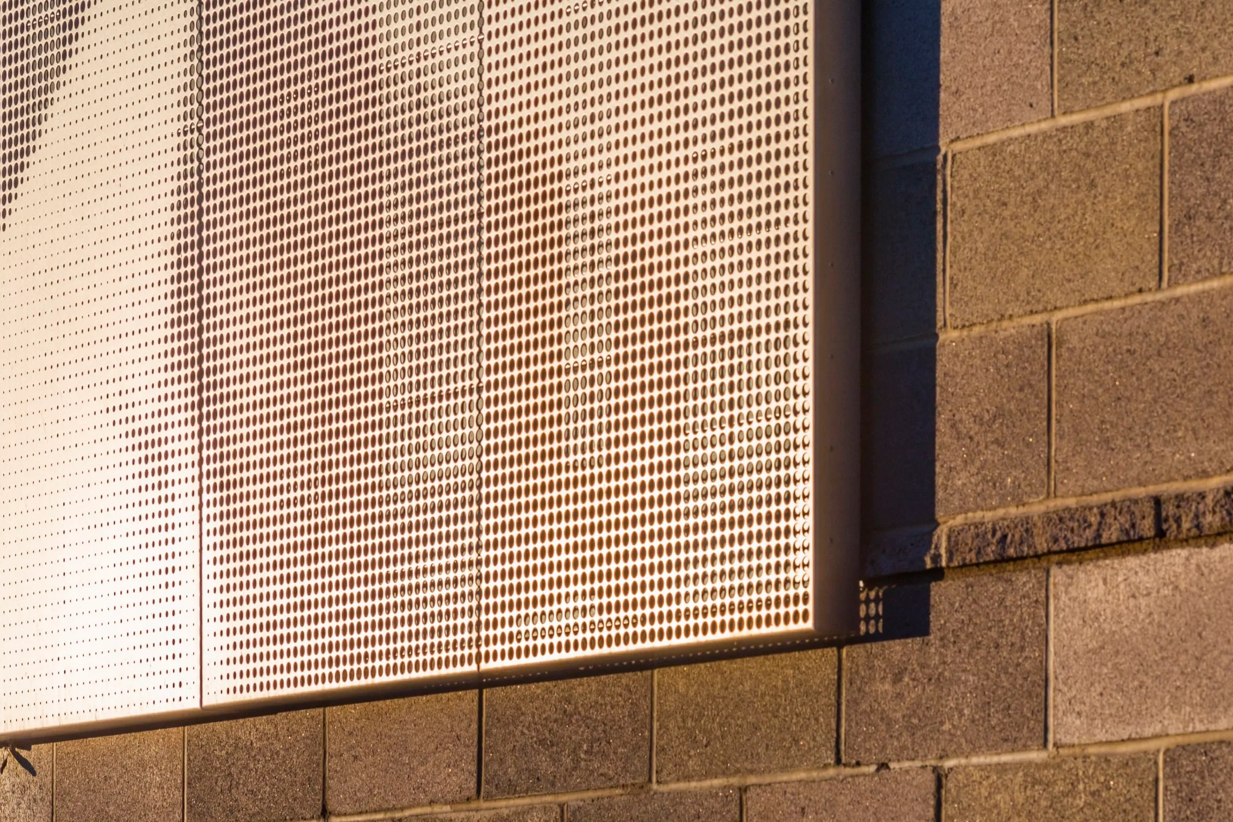 The mural’s edge meeting the block wall in warm light