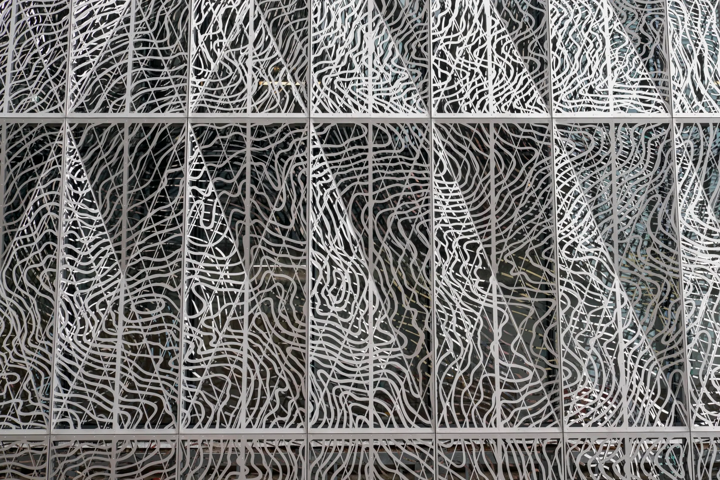 Close on the façade’s layered, map-like cut steel
